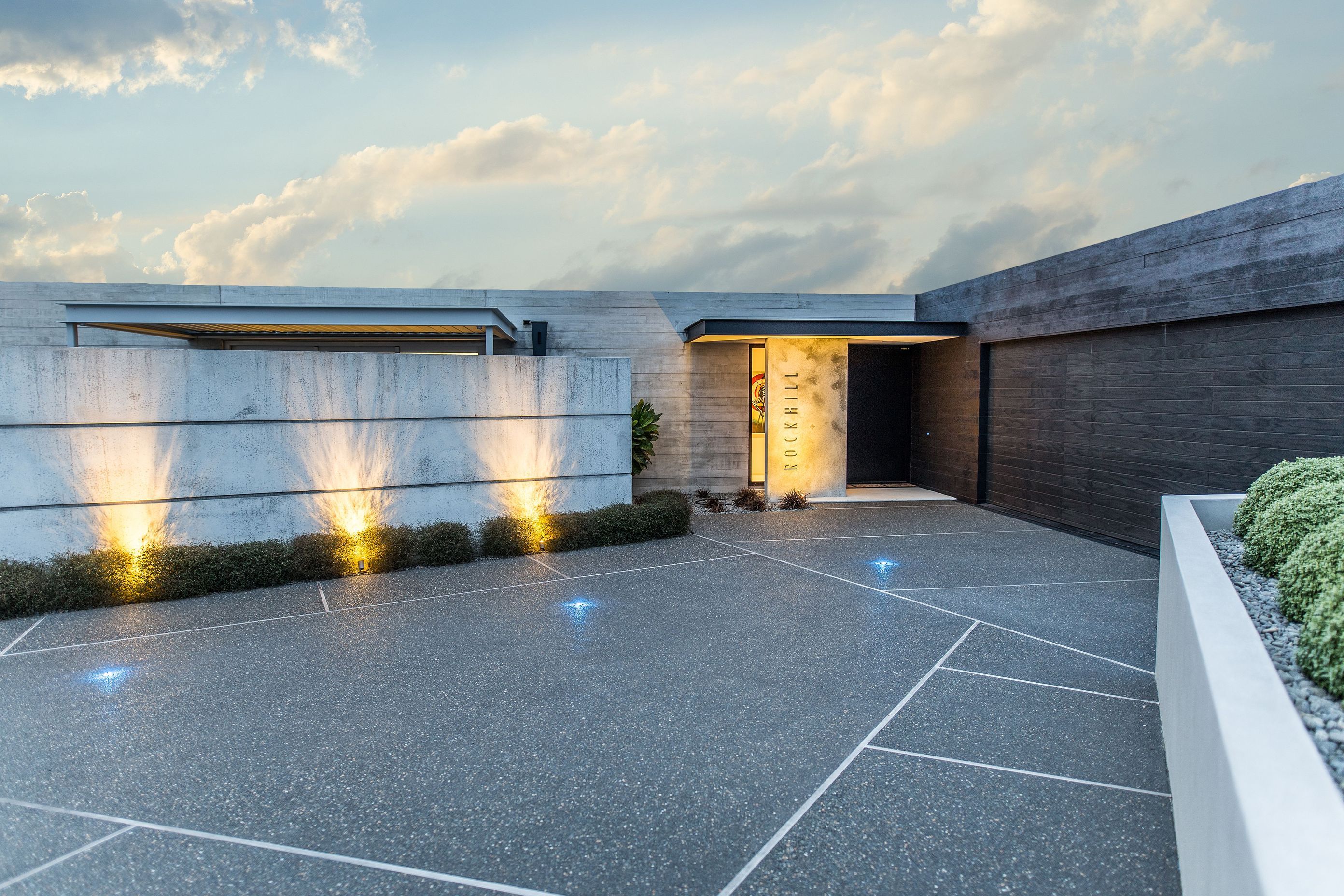 The house has been designed to sit wide and low within its surroundings, presenting a somewhat brutalist face to the street. The precast wall contains a small courtyard that provides sheltered outdoor living.