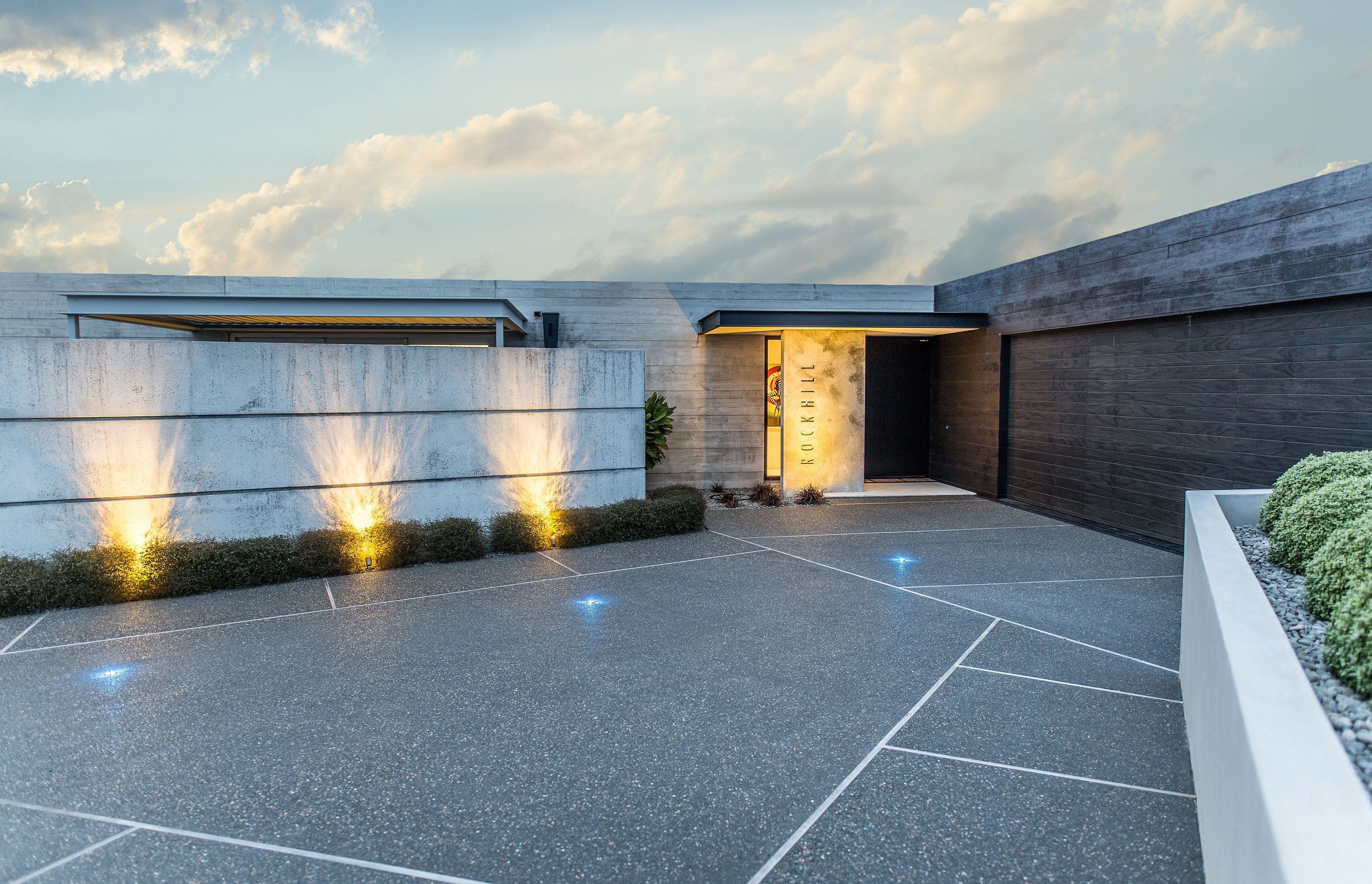 The house has been designed to sit wide and low within its surroundings, presenting a somewhat brutalist face to the street. The precast wall contains a small courtyard that provides sheltered outdoor living.