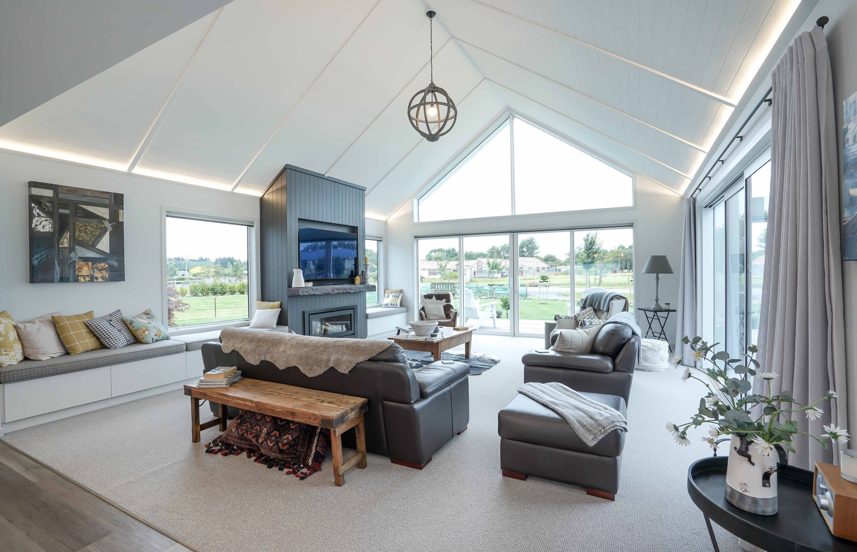 Living area of the home that has made full use of the space by using high ceilings and floor to ceiling windows.