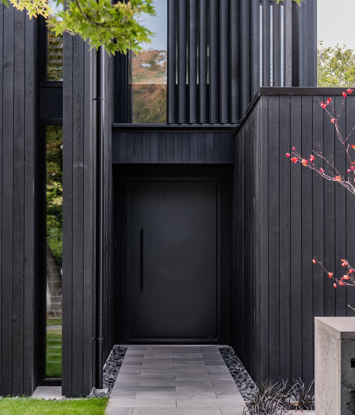The front door blends with the rest of the exterior materiality.