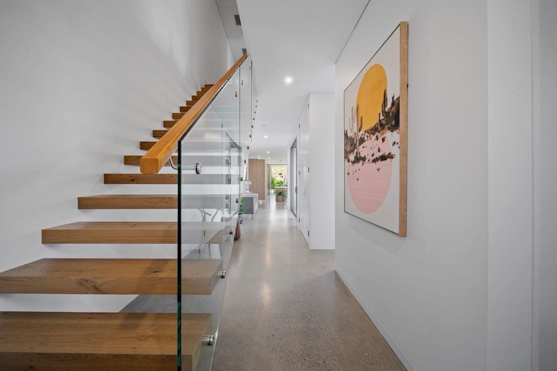 Open floating stairs to the upper floor, clean circulation all the way to the living areas.