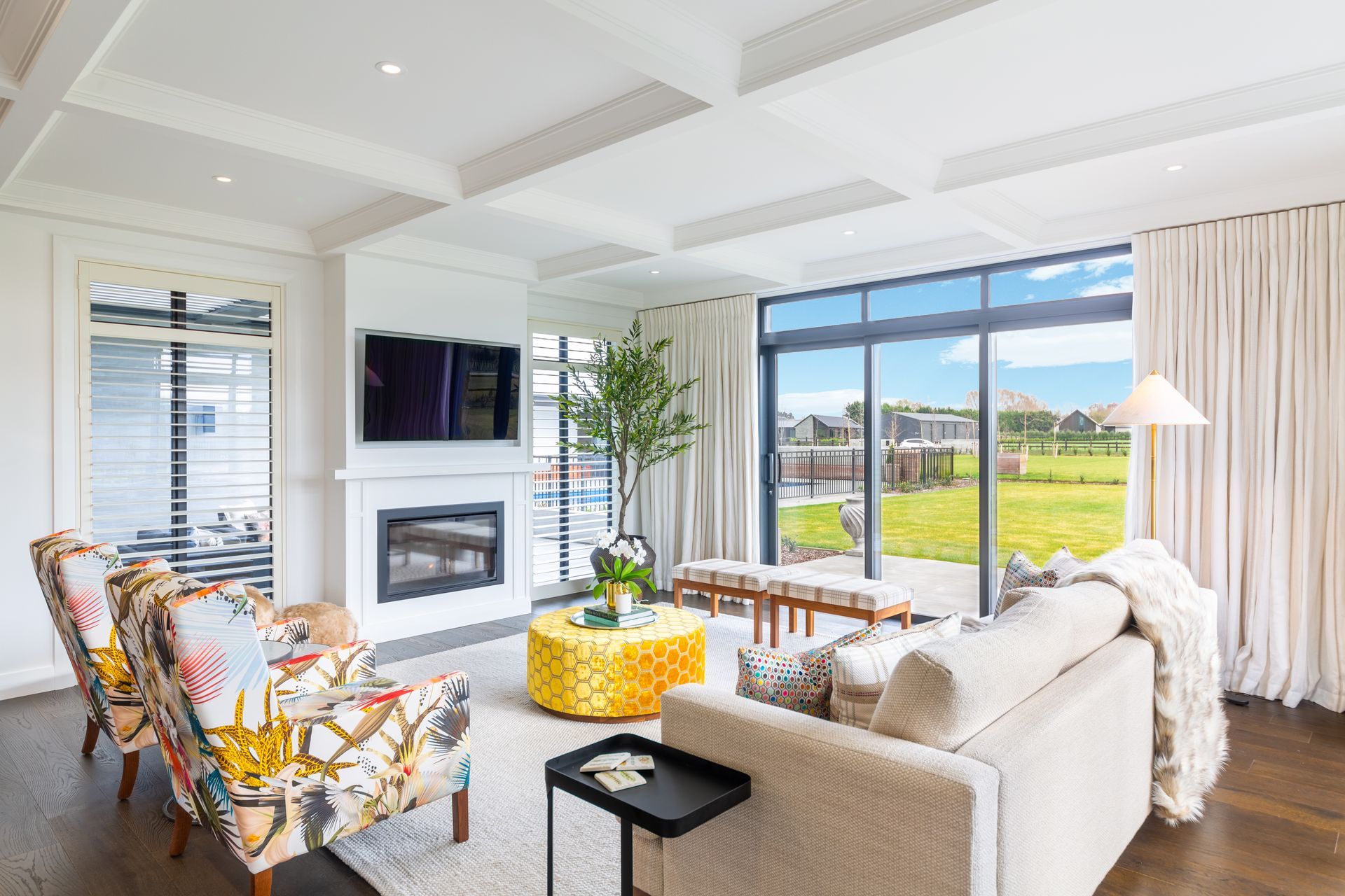 A gas fireplace warms the living space and backs against the outdoor courtyard with louvred roof.