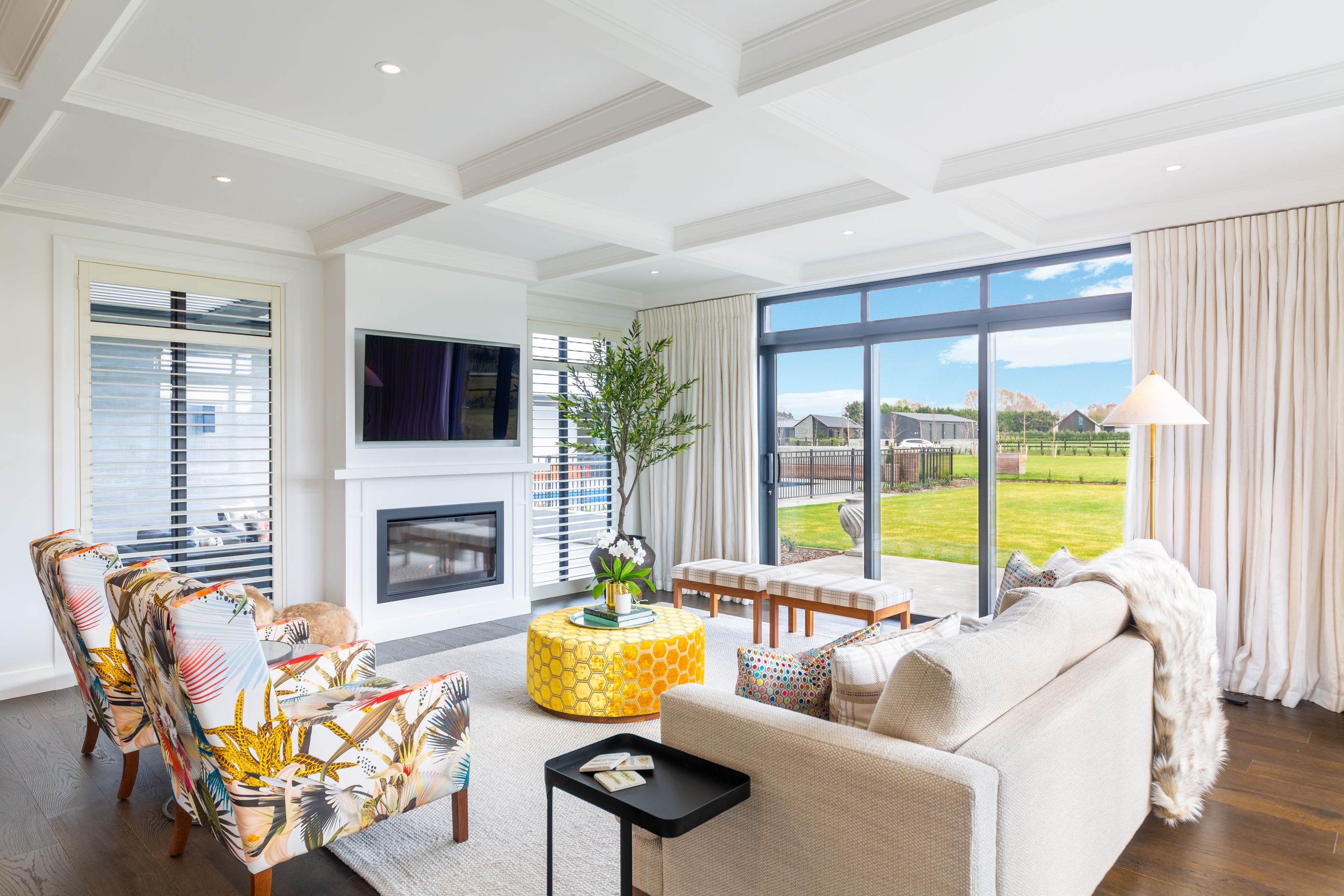 A gas fireplace warms the living space and backs against the outdoor courtyard with louvred roof.
