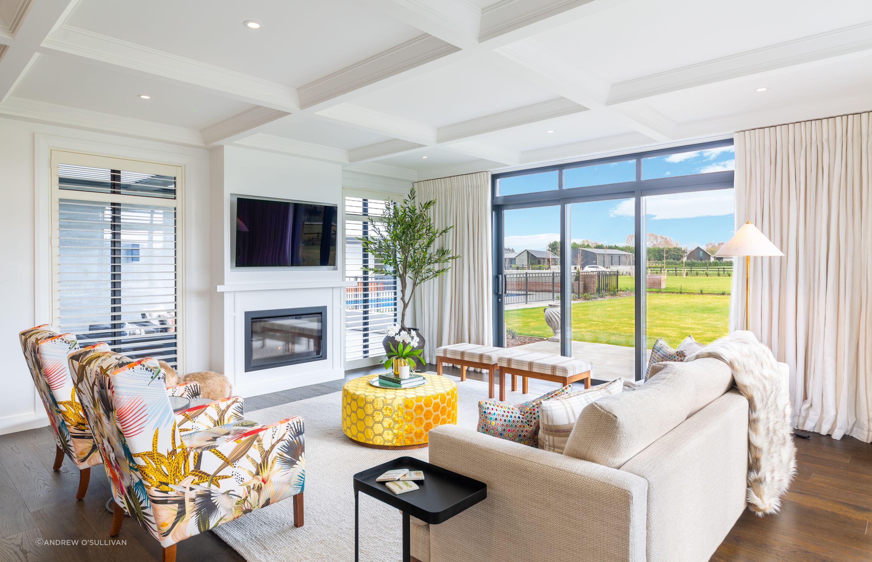 A gas fireplace warms the living space and backs against the outdoor courtyard with louvred roof.