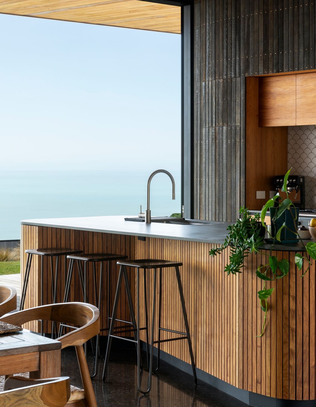 The kitchen island reflects the same curves and warm materiality as the rest of the house.