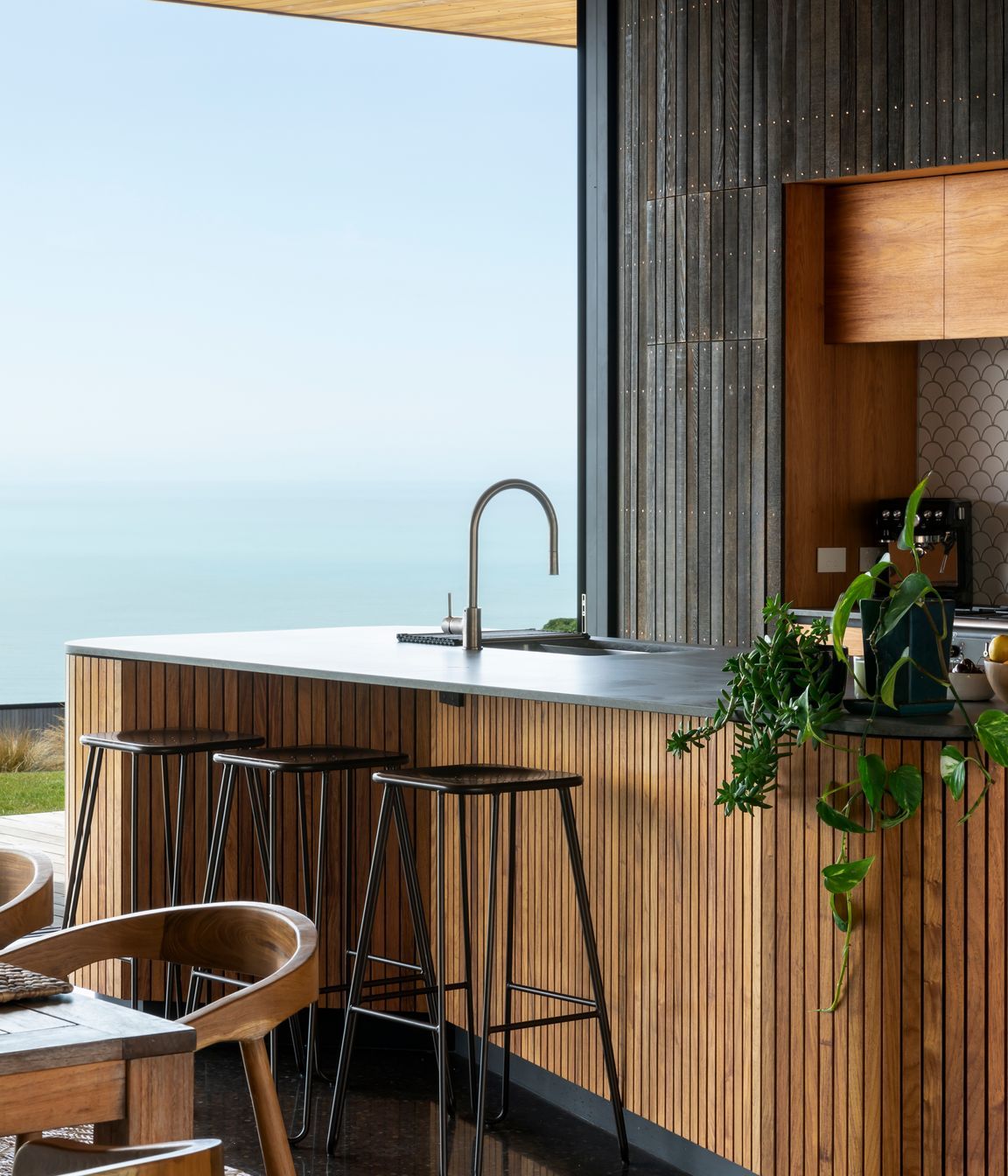 The kitchen island reflects the same curves and warm materiality as the rest of the house.