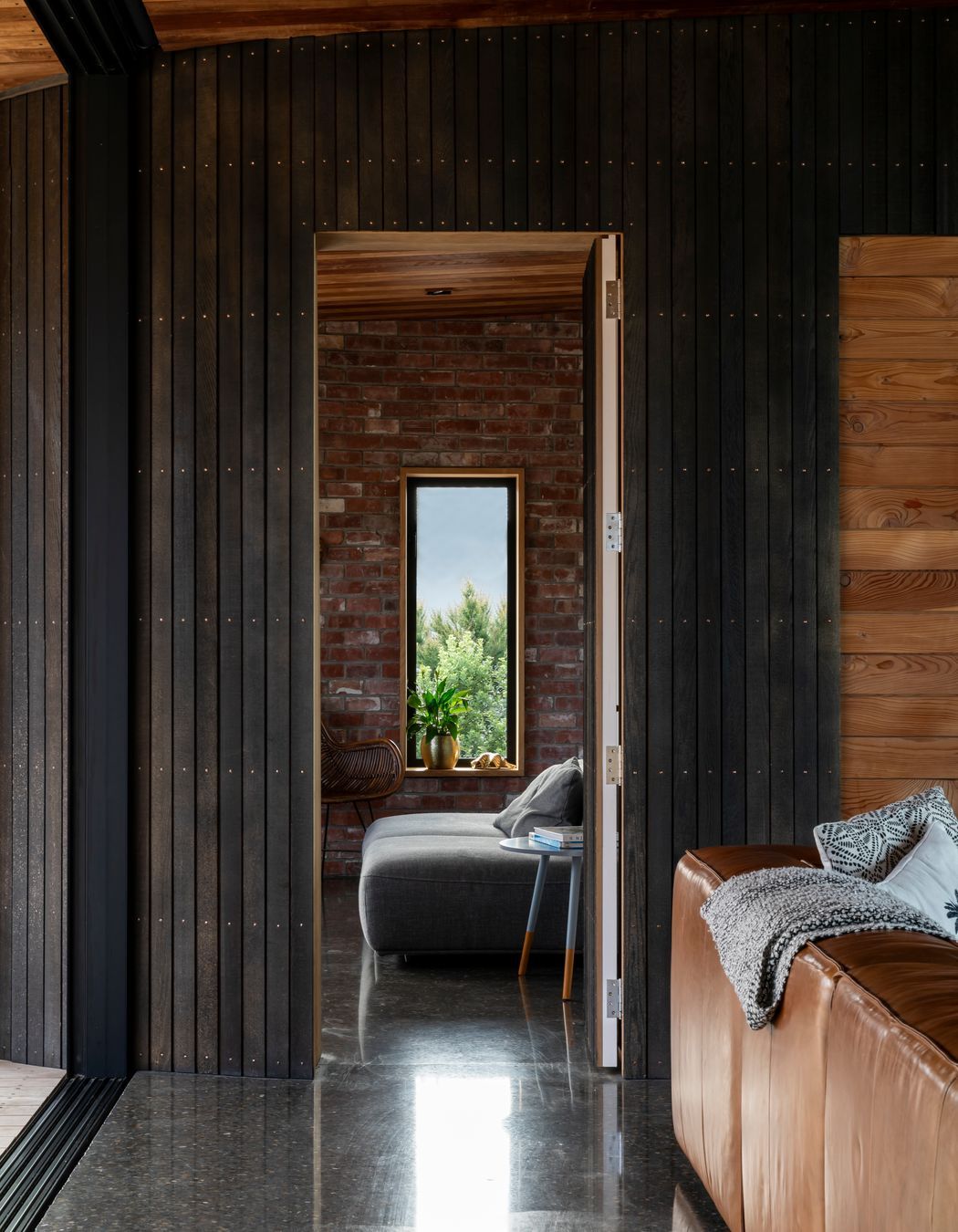 A wall and door paneled in a dark, stained cedar sit flush with each other when closed.