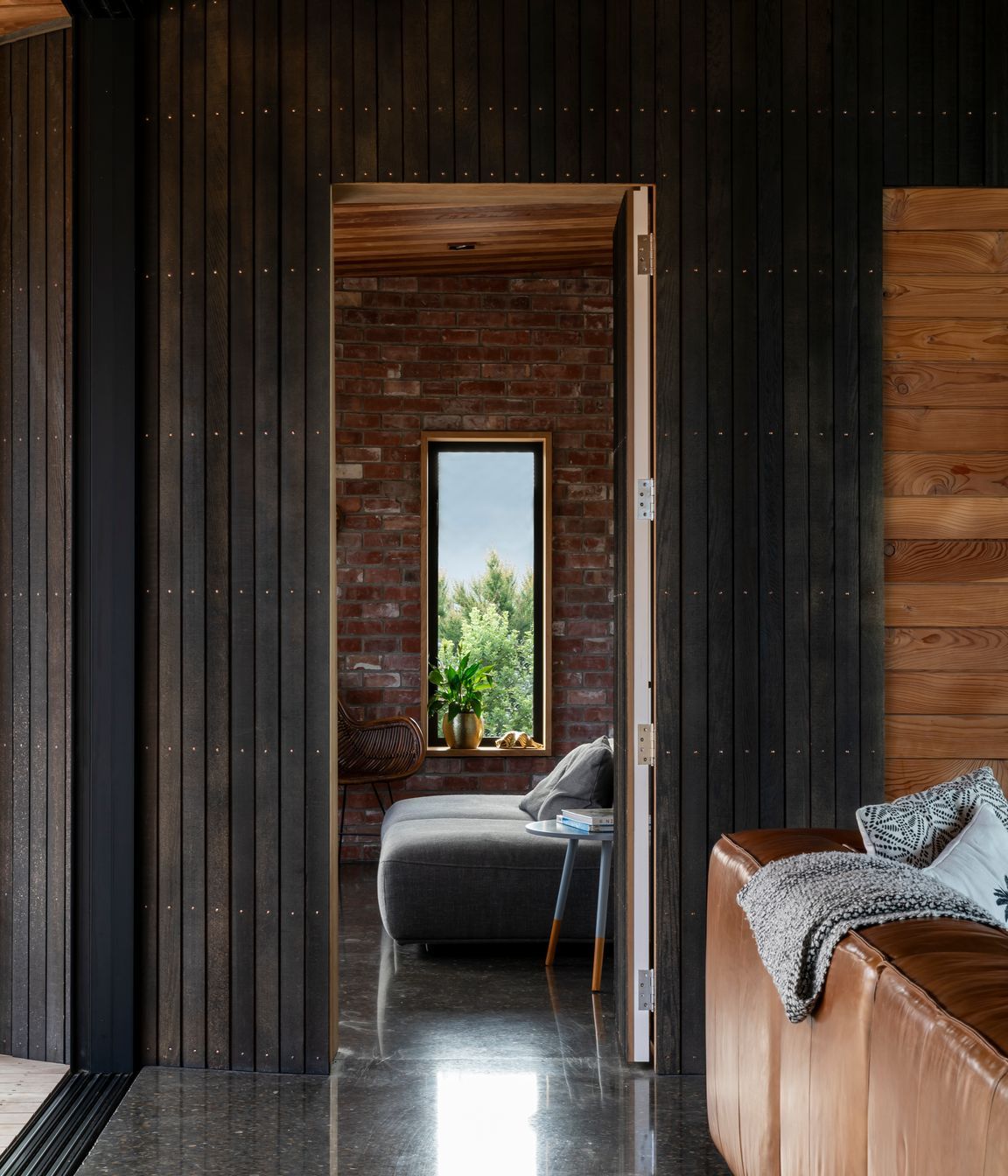 A wall and door paneled in a dark, stained cedar sit flush with each other when closed.