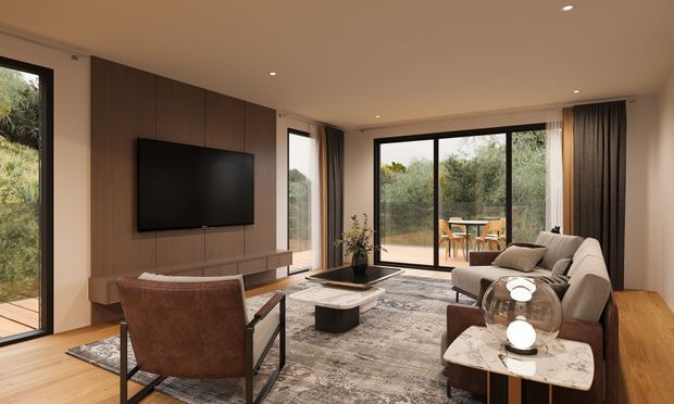 Contemporary living room with a large sectional sofa, leather lounge chair, wall-mounted television, low media console, coffee table, and patterned area rug. Full-height glazed doors and windows open to a planted outdoor area, while dark timber wall panelling and warm timber flooring add contrast to the neutral furnishings. Recessed ceiling lights and full-height curtains complete the refined interior.