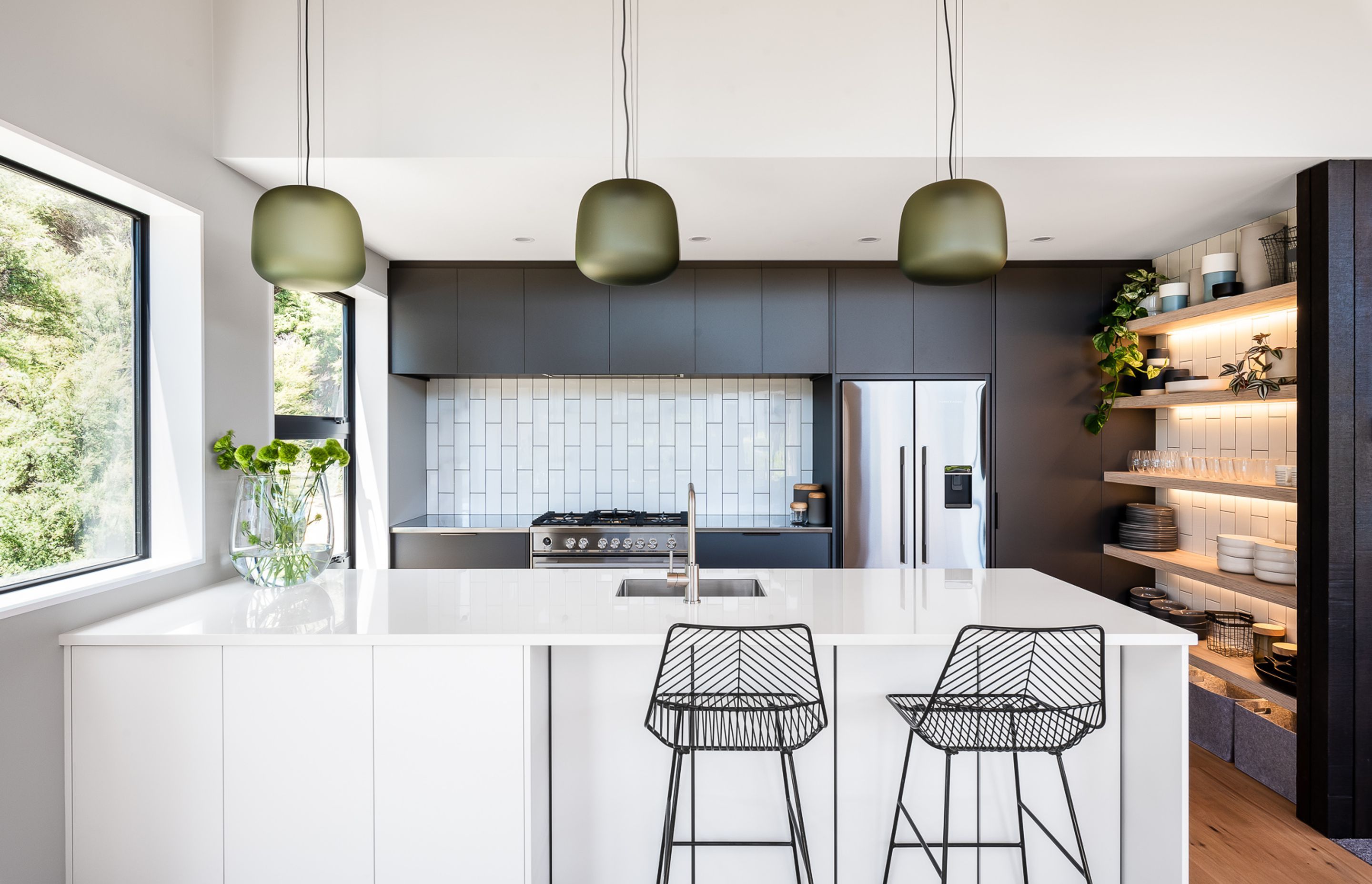 LED strip lighting adds ambiance to the open-face shelving, while the mix of darkly stained and white cabinetry sets up a very modern-classic feel to the kitchen.