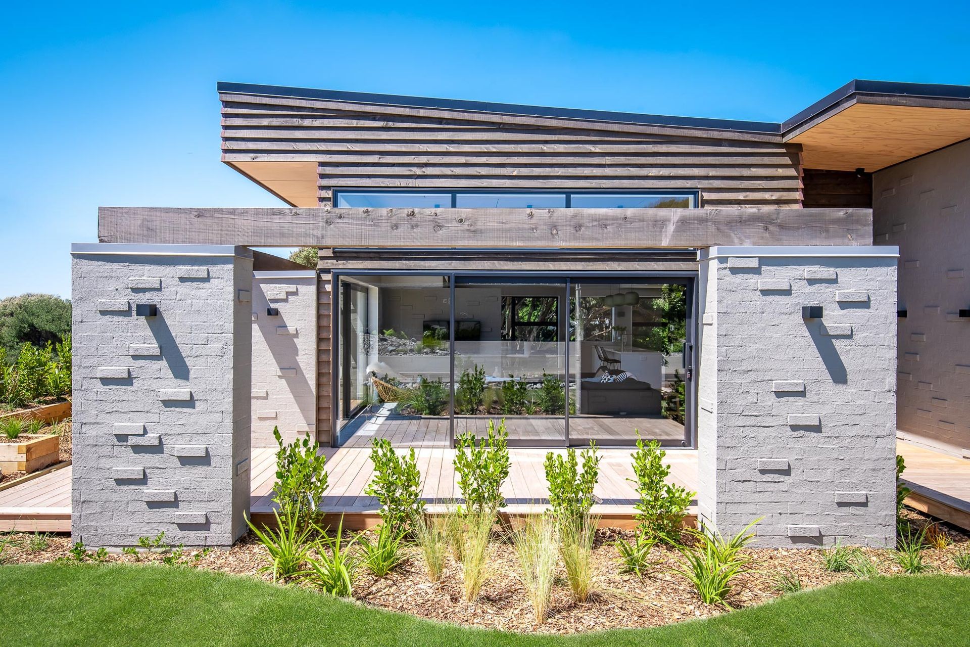 The over-width columns and macrocarpa beams impart a very durable feel, visually anchoring the outdoor areas to the site.