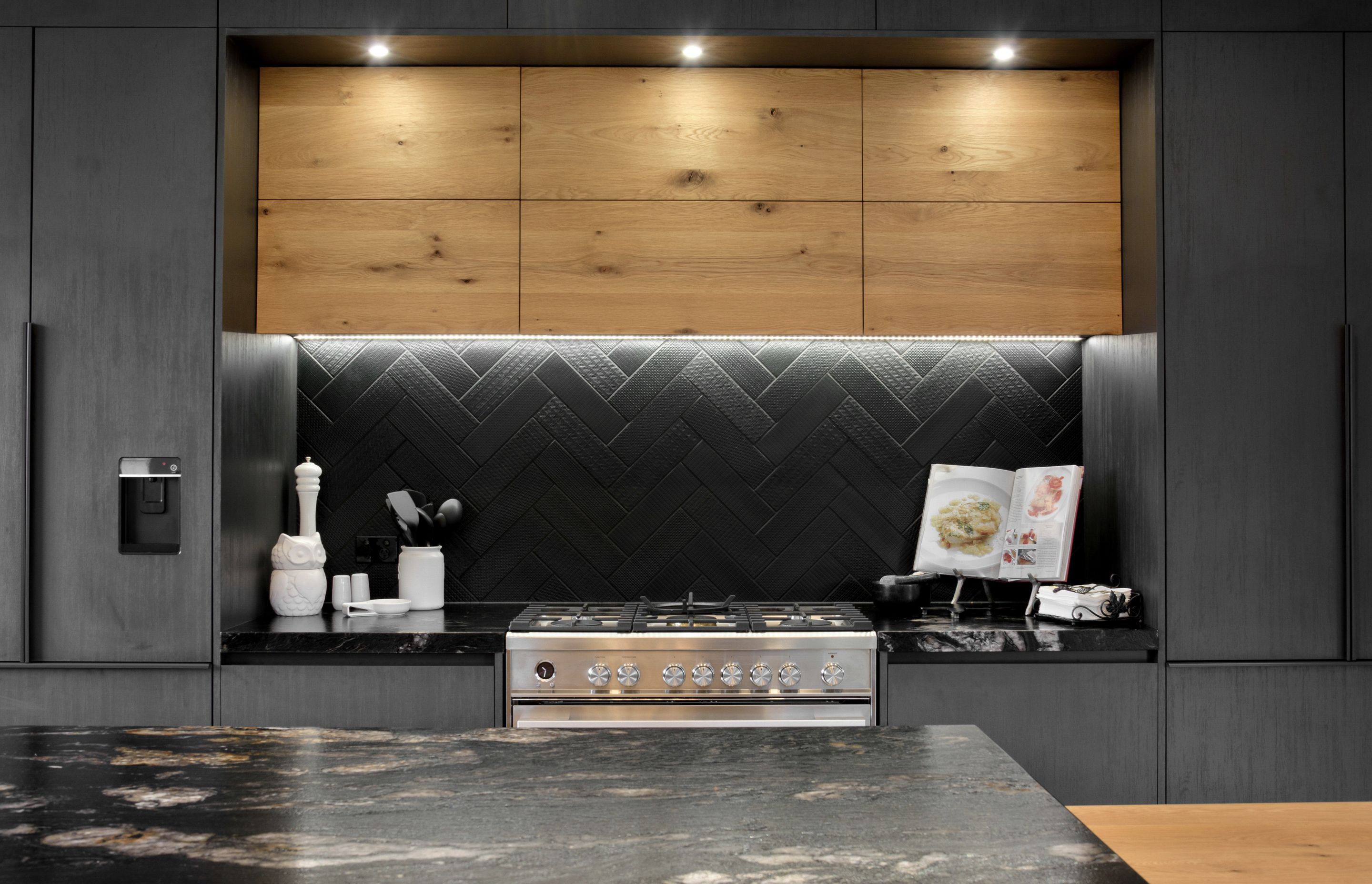 The gorgeous granite and herringbone tiles of the kitchen create a feature splashback.