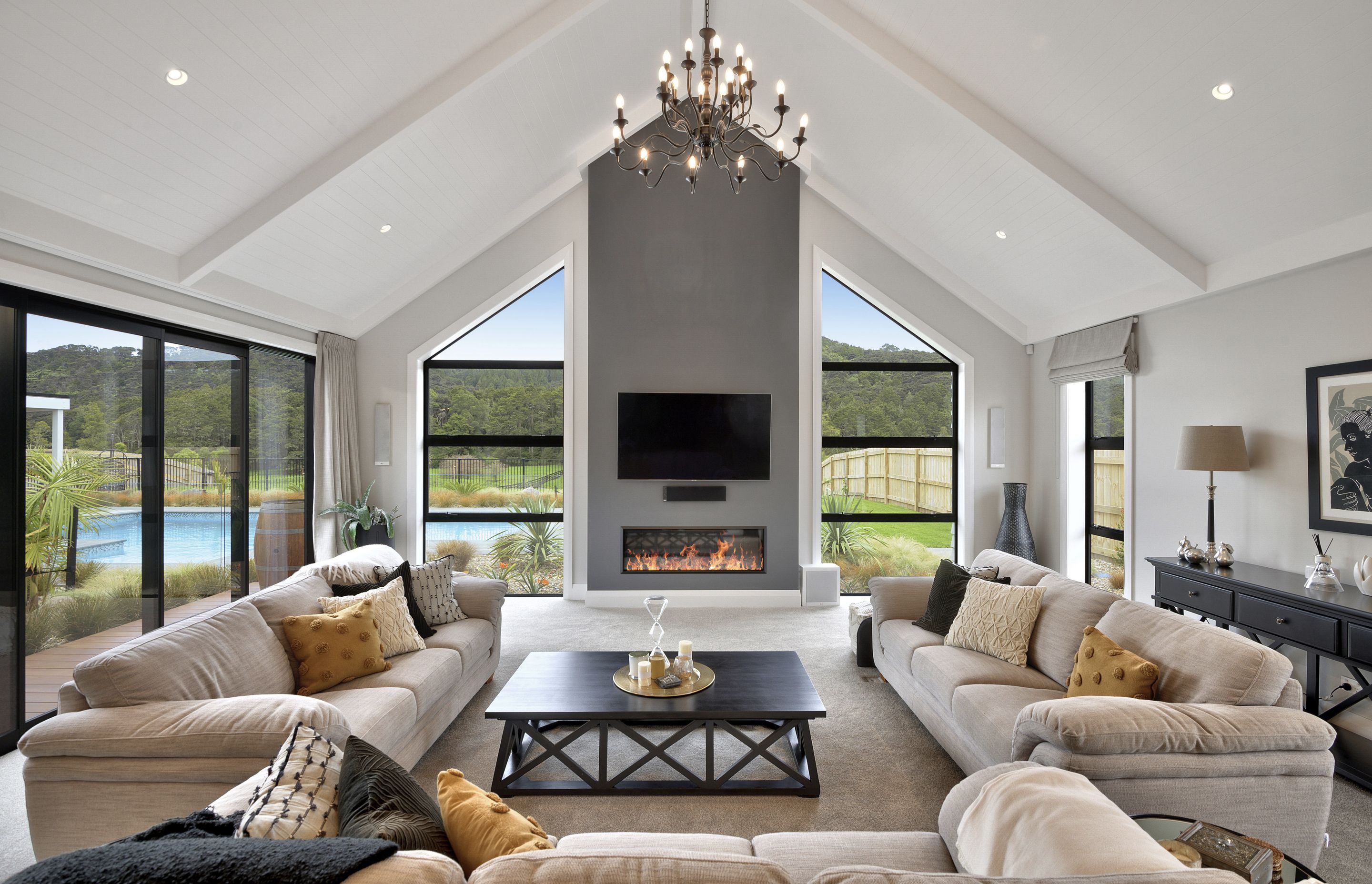 The lounge space with gas fire looks out to the pool and bush beyond.