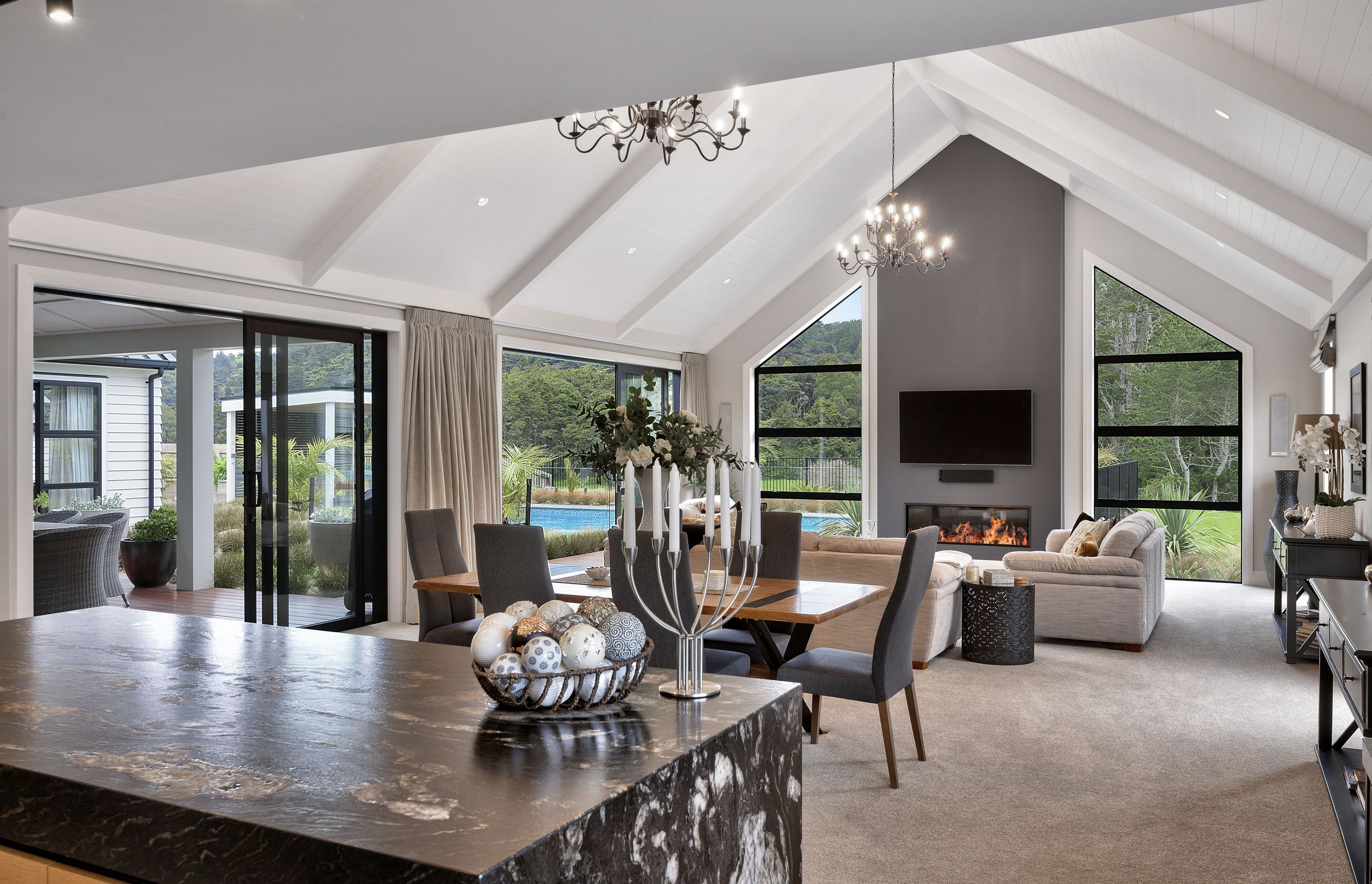 Within the larger wing, kitchen, dining and living areas sprawl across a grand room with spectacular high-pitched cathedral ceilings and extensive views of the native bush.