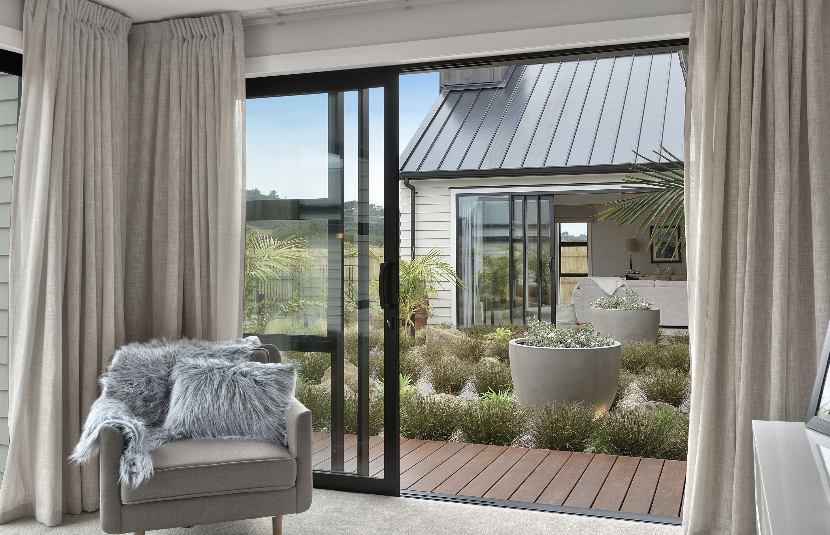 The front bedroom has beautiful indoor-outdoor flow to the garden and pool.