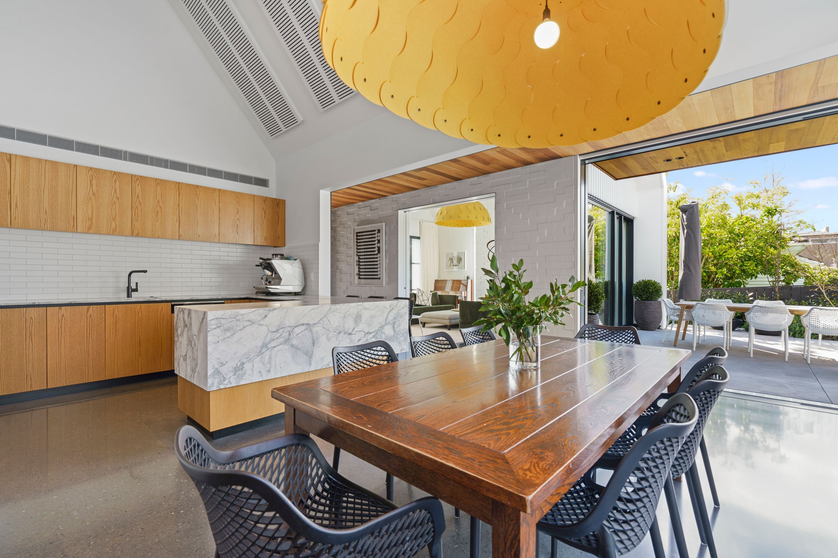 The open plan kitchen and dining area is light and breezy thanks to the neutral colour palette and the courtyard spaces on two sides.