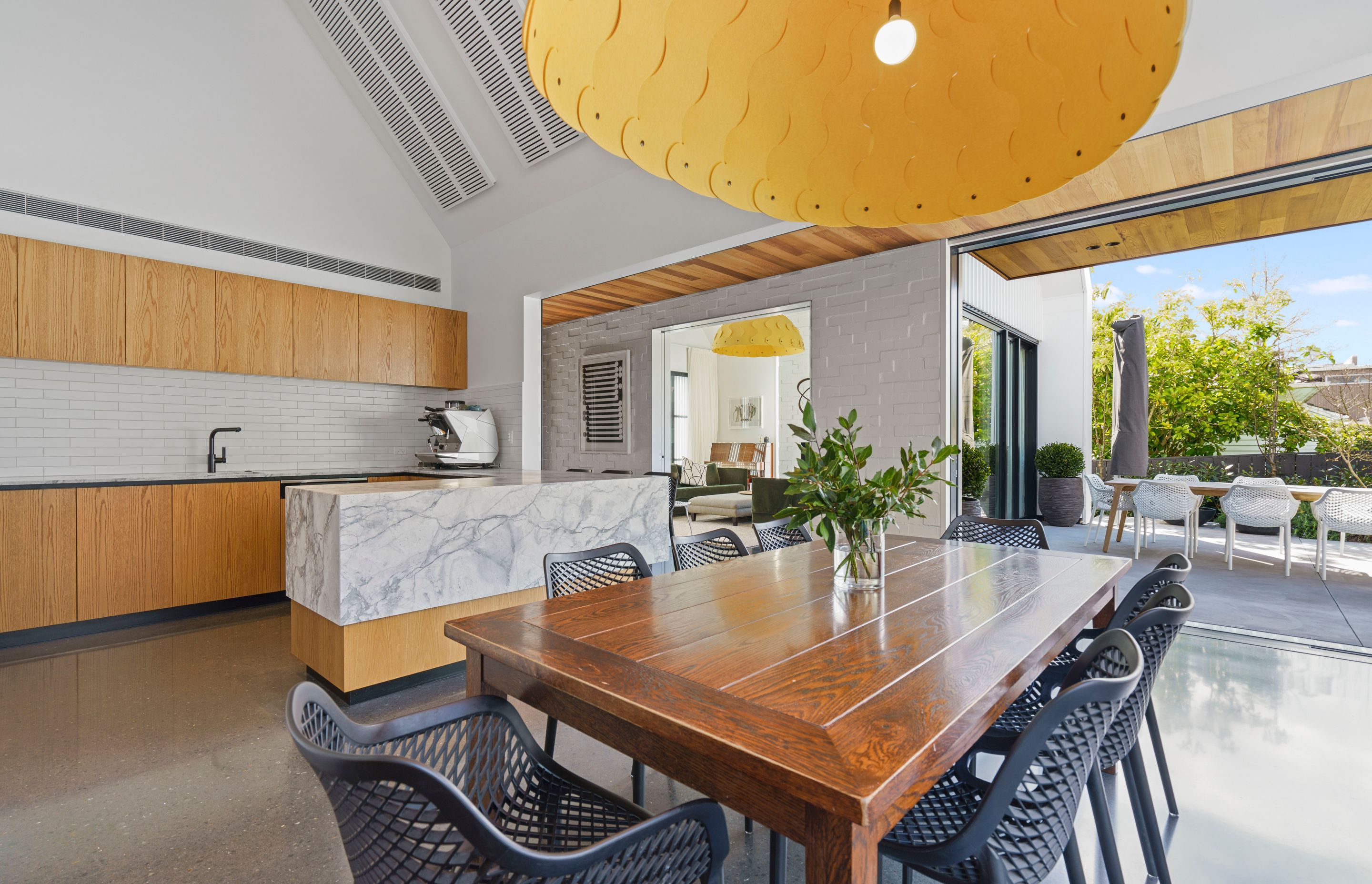 The open plan kitchen and dining area is light and breezy thanks to the neutral colour palette and the courtyard spaces on two sides.