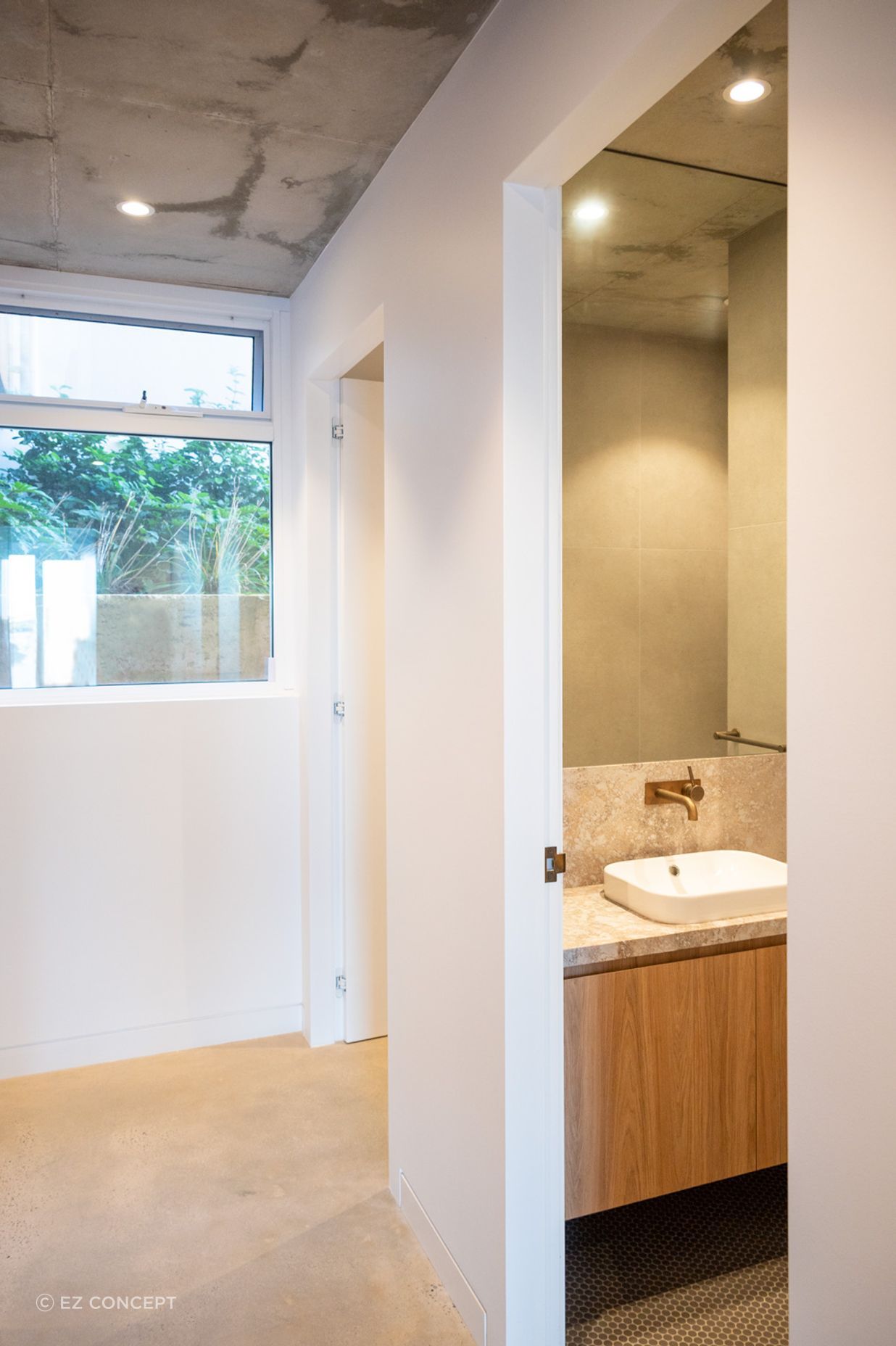 The hallway leading through to the bathroom holds minimal architectural detailing for a modern look.