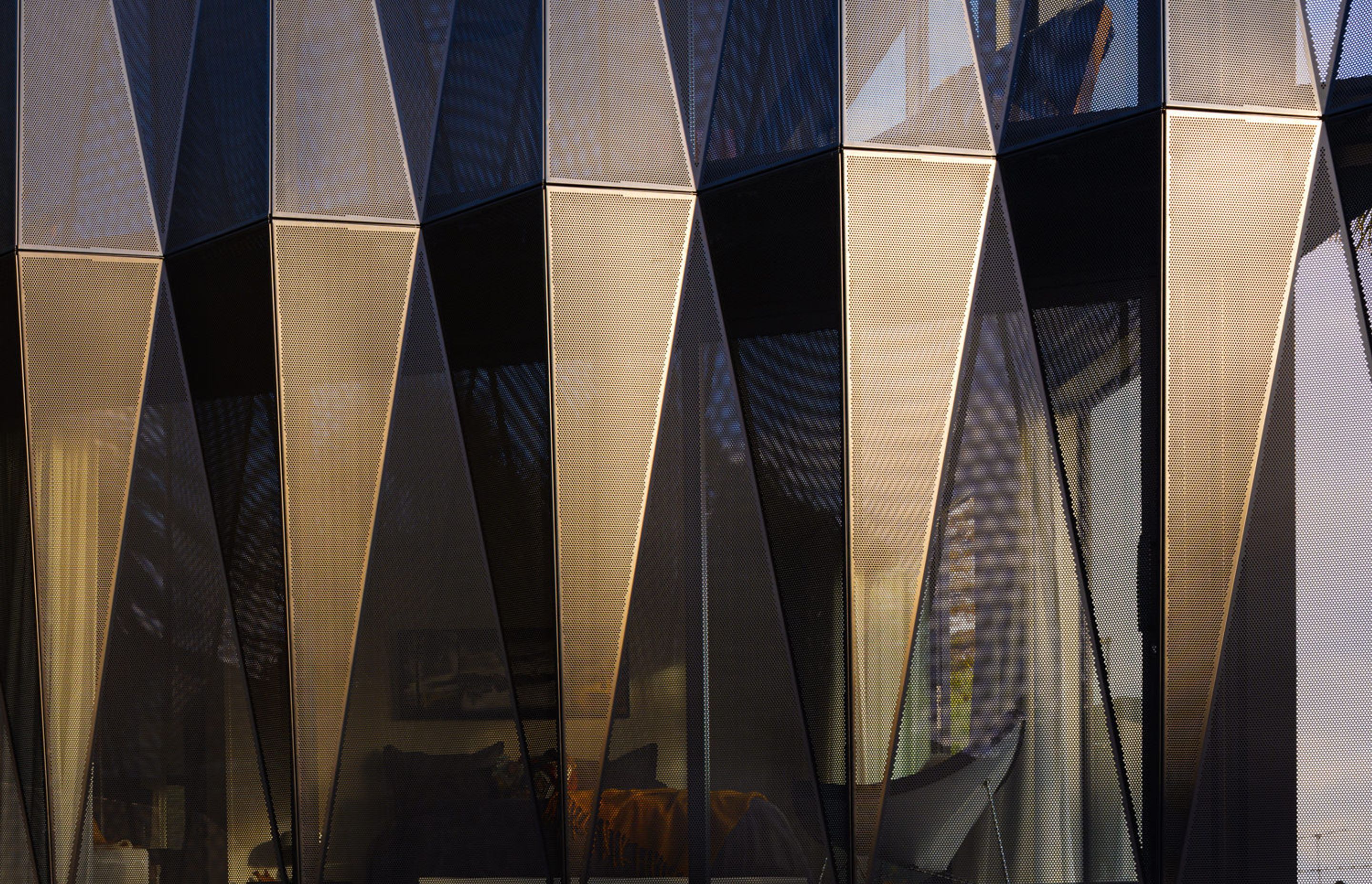 Geometric shade fins made from perforated, powder-coated aluminium were devised to address issues around light, shade and privacy on the east-facing street frontage.