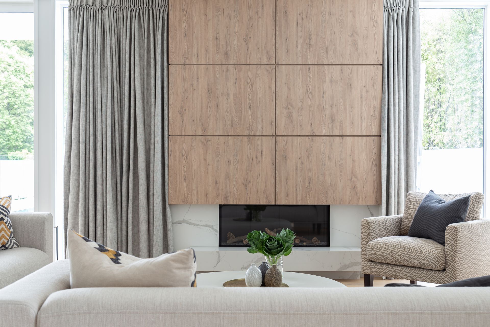 The warm timber paneling of the fireplace juxtaposes against the elegant marble hearth.