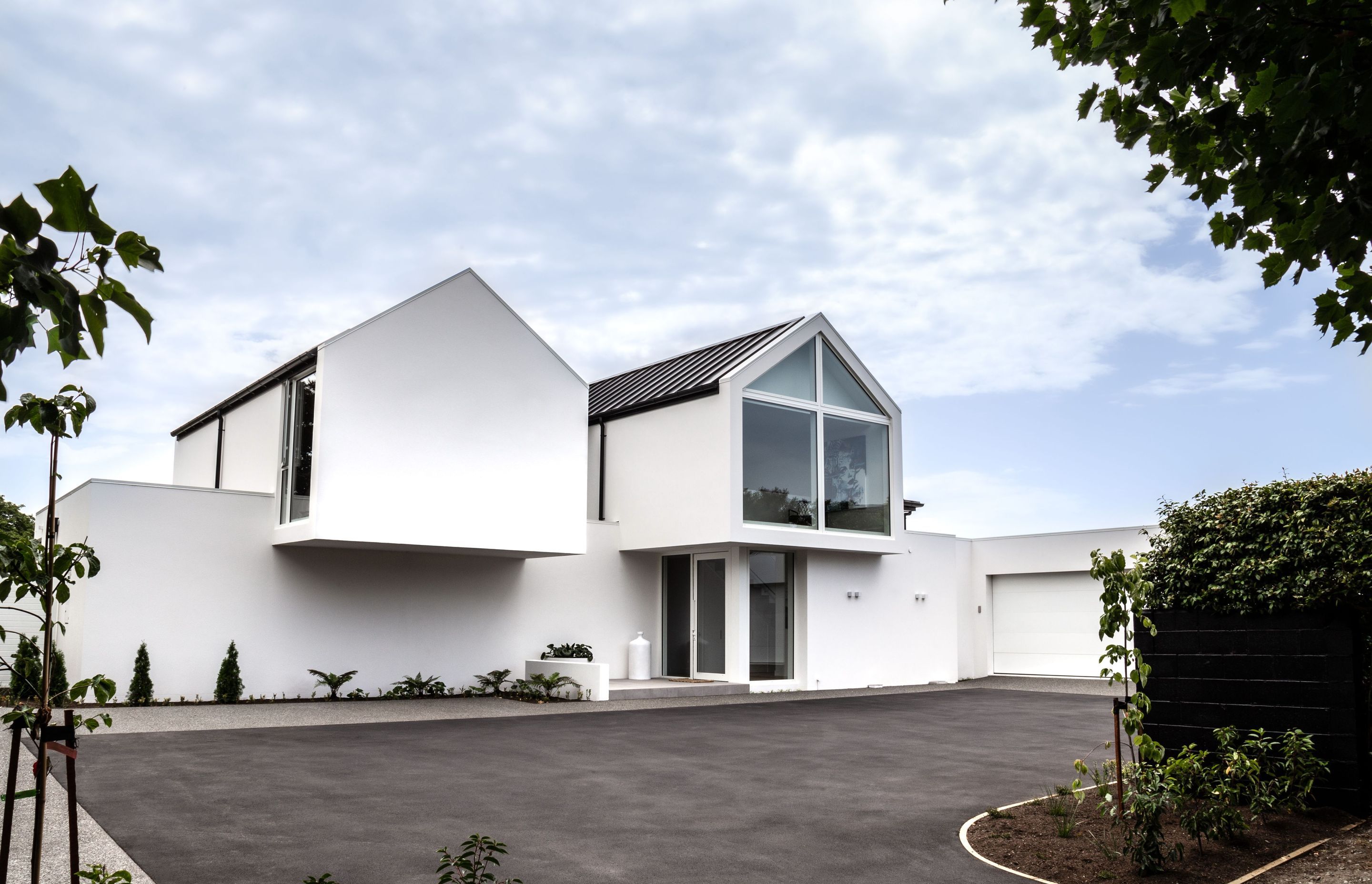 The entry courtyard with cantilevered gable forms and discreet entrance tucked underneath.