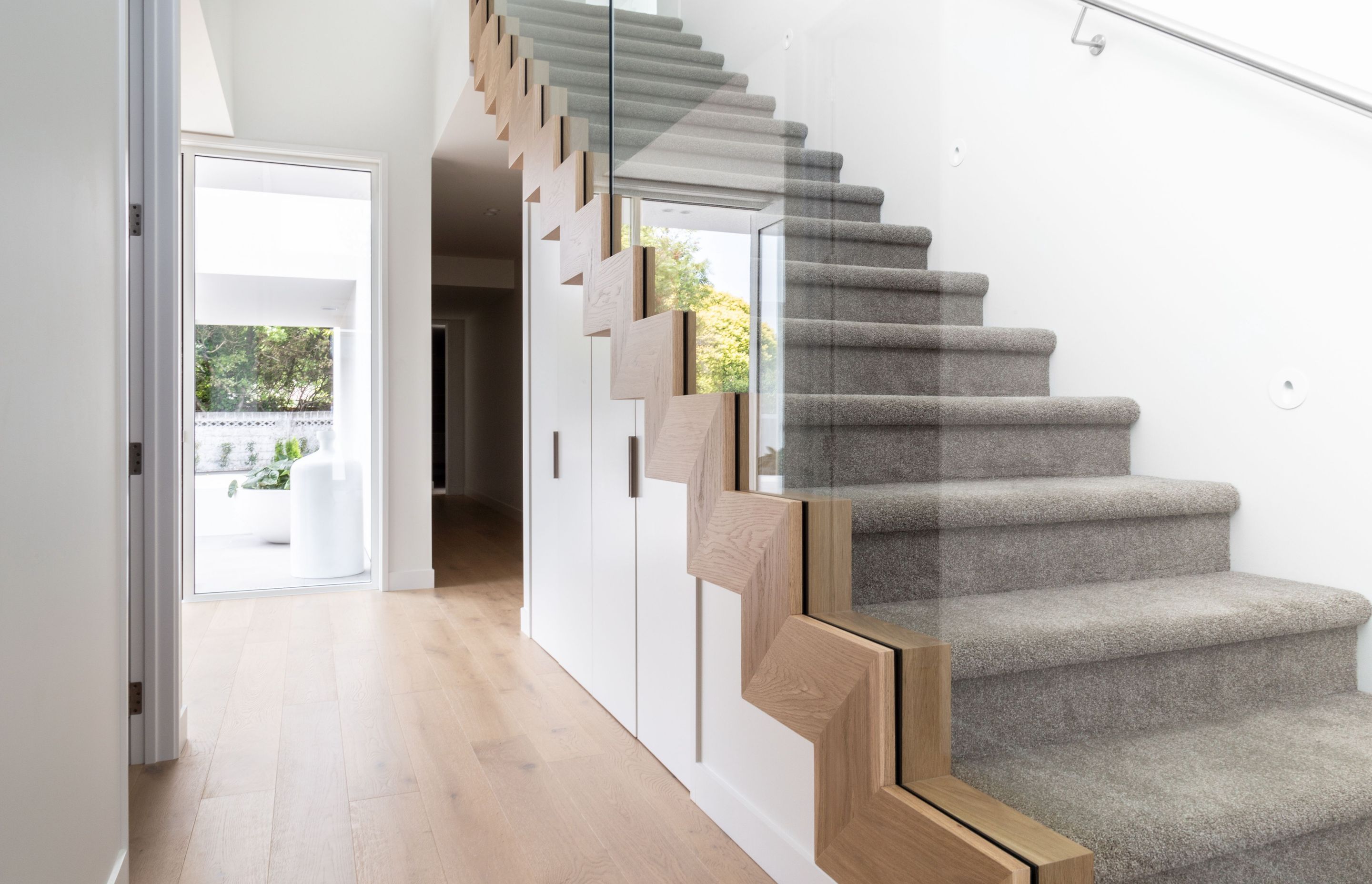 The stairway features a beautiful timber detailing that ties it into the warm oak floor.