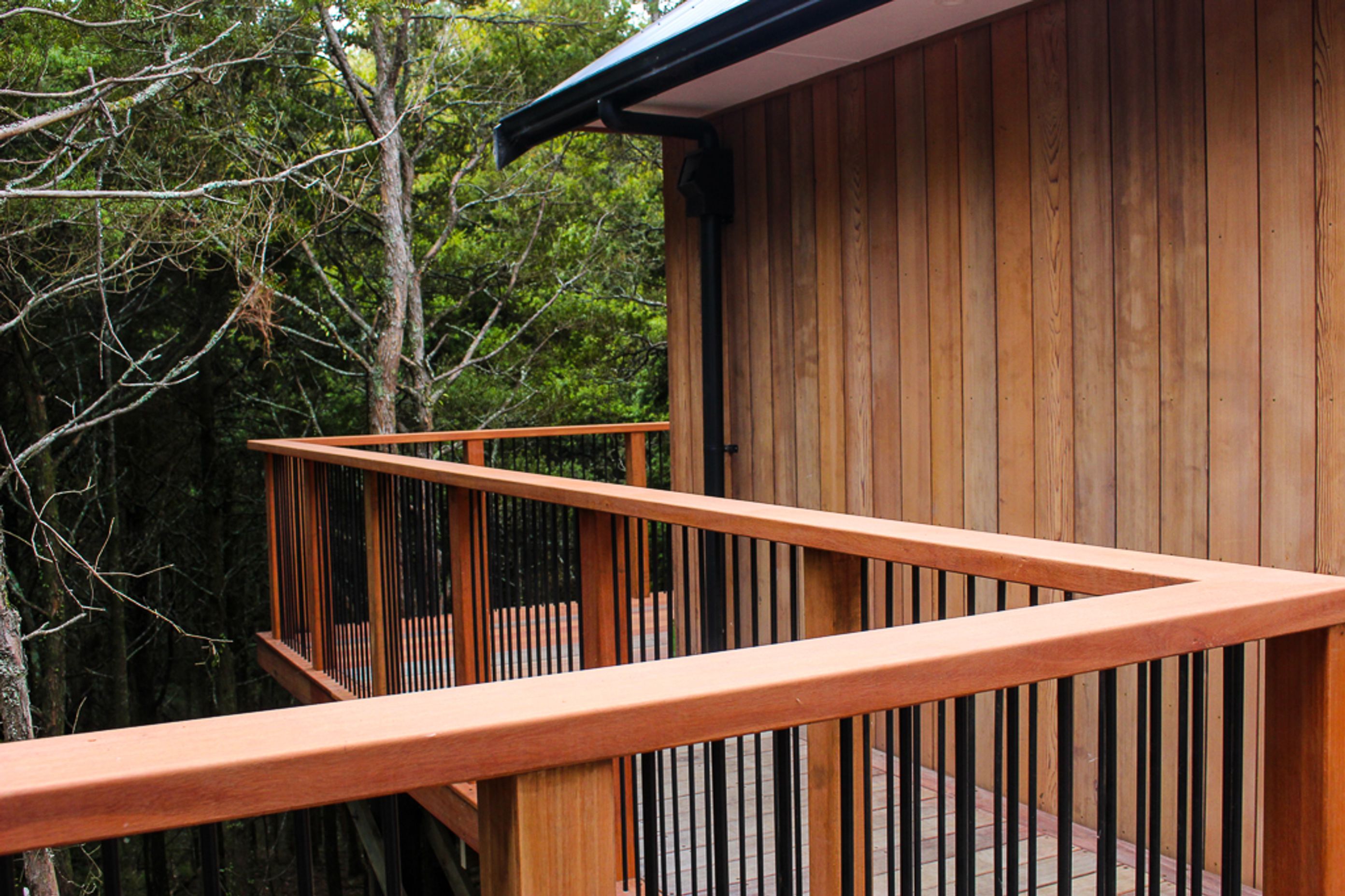 Custom built deck railing / balustrade is made from powder coated aluminum contrasted with Saligna timber - a Hardwood NZ grown Gum.