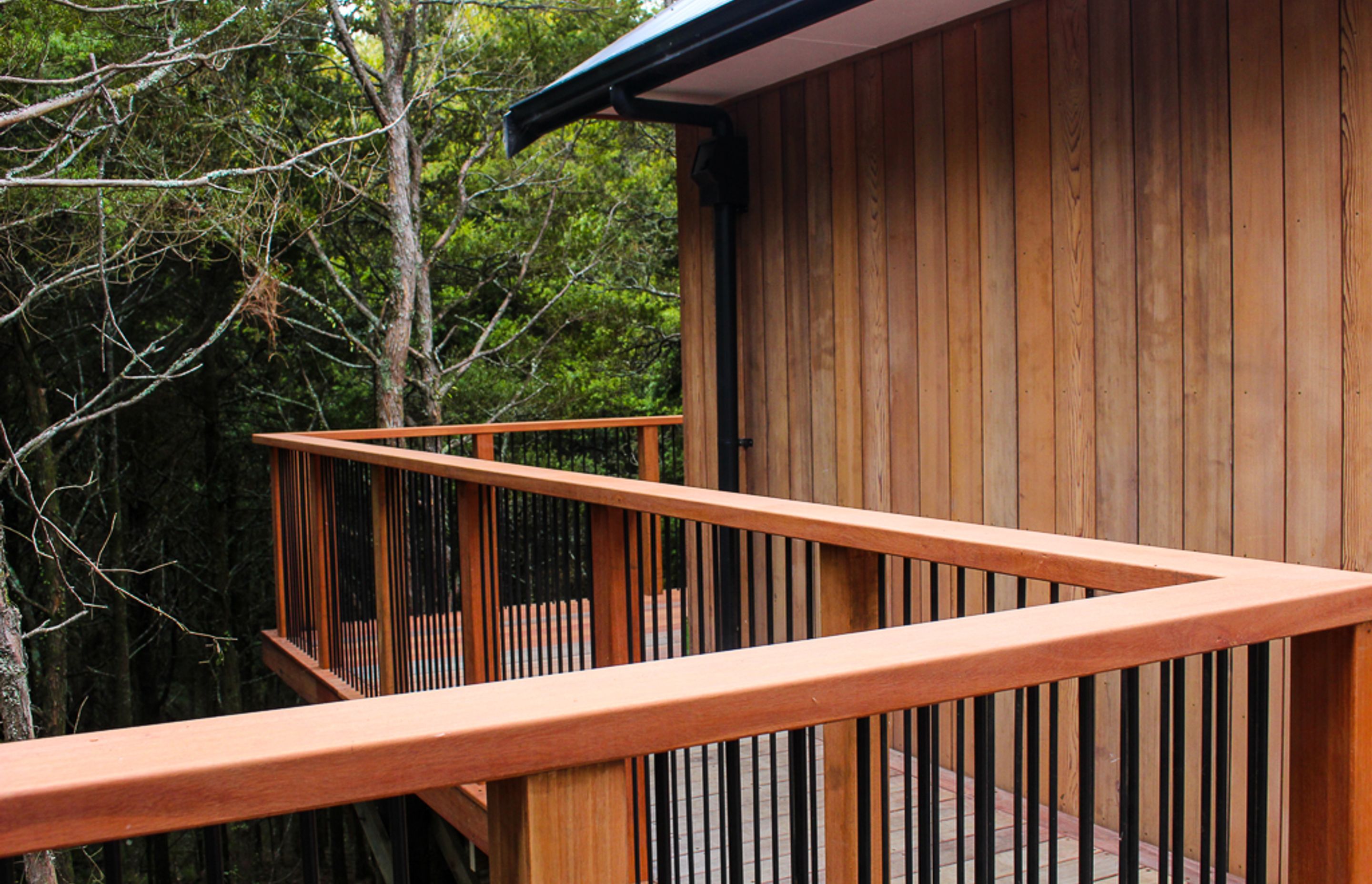 Custom built deck railing / balustrade is made from powder coated aluminum contrasted with Saligna timber - a Hardwood NZ grown Gum.
