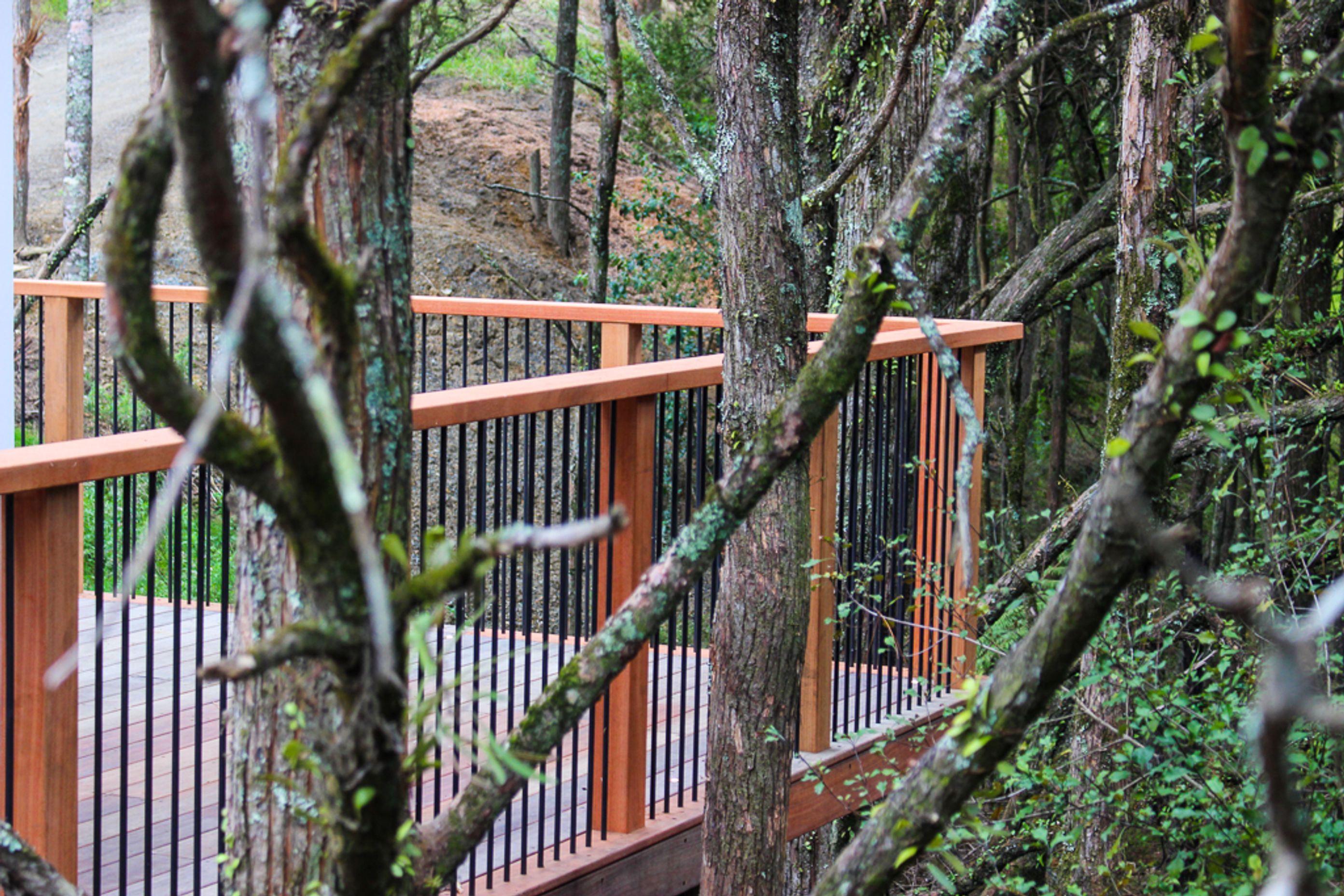 Custom built deck railing / balustrade is made from powder coated aluminum contrasted with Saligna timber.  Nestled among the trees this will only get better with age as the timber silvers
