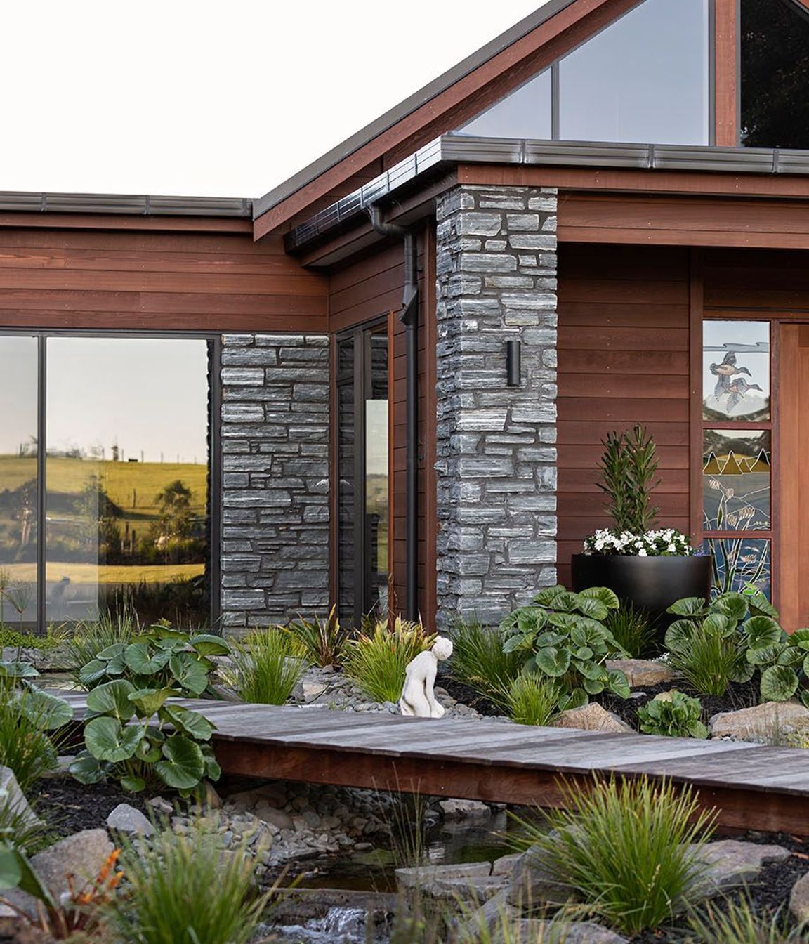 Horizontal Cedar weatherboard and schist cladding are combined for an effortless country home.
