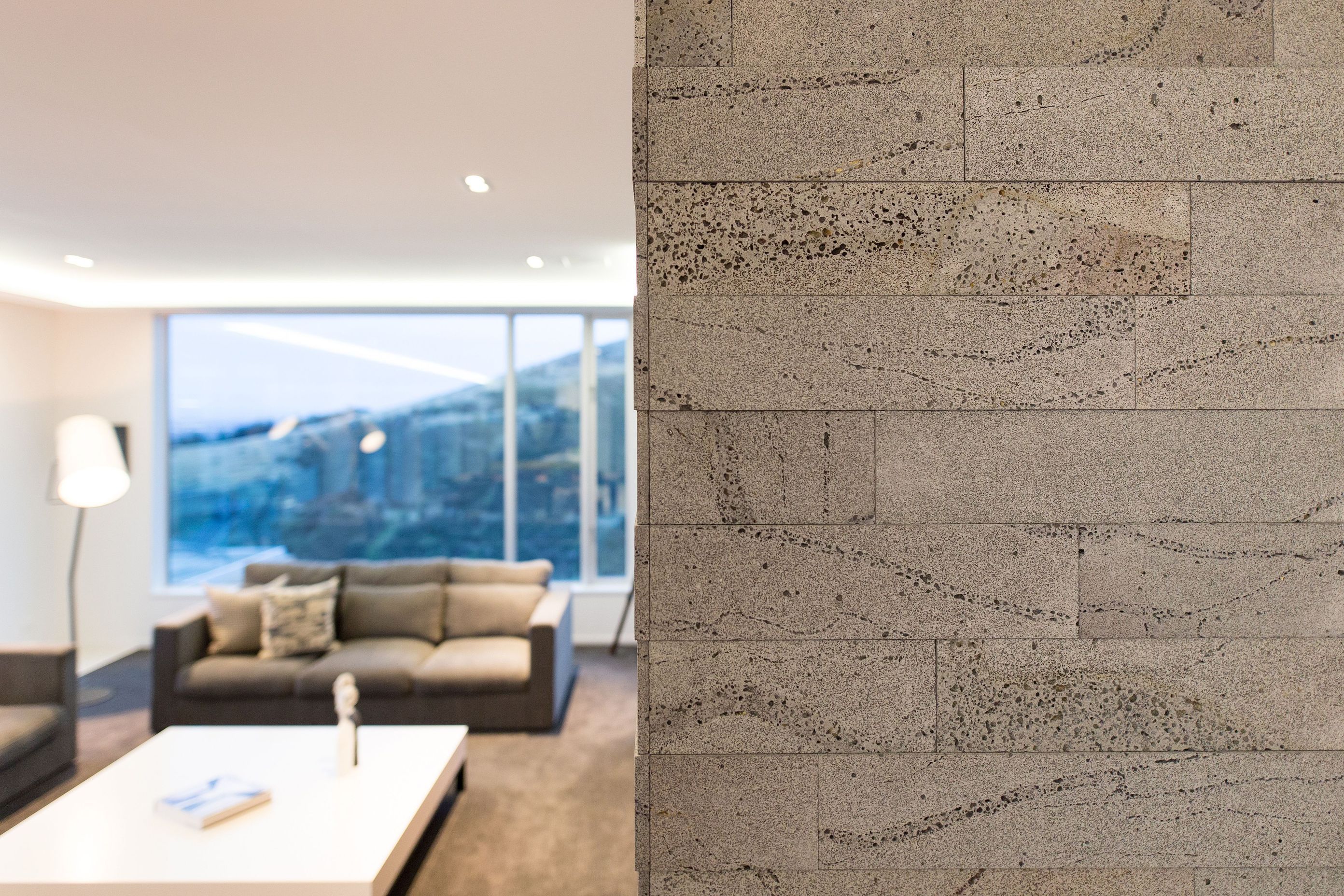 Timaru bluestone in two different depths has been used to clad the fireplace, again mimicking the board-formed concrete exterior.