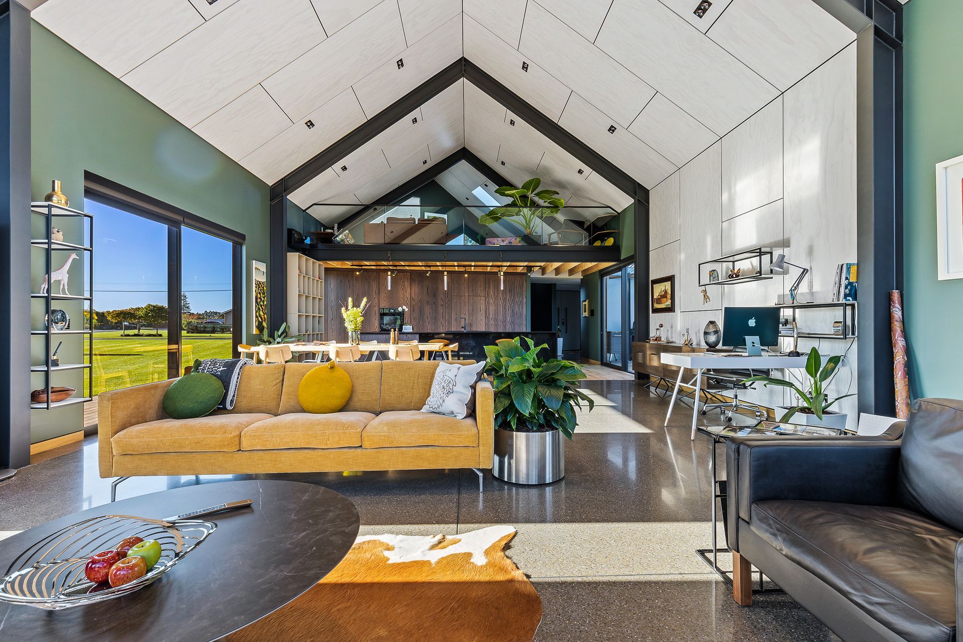 The PlyPlay plywood ceiling with shadow detailing extends down a section of wall in the open-plan dining and living area.
