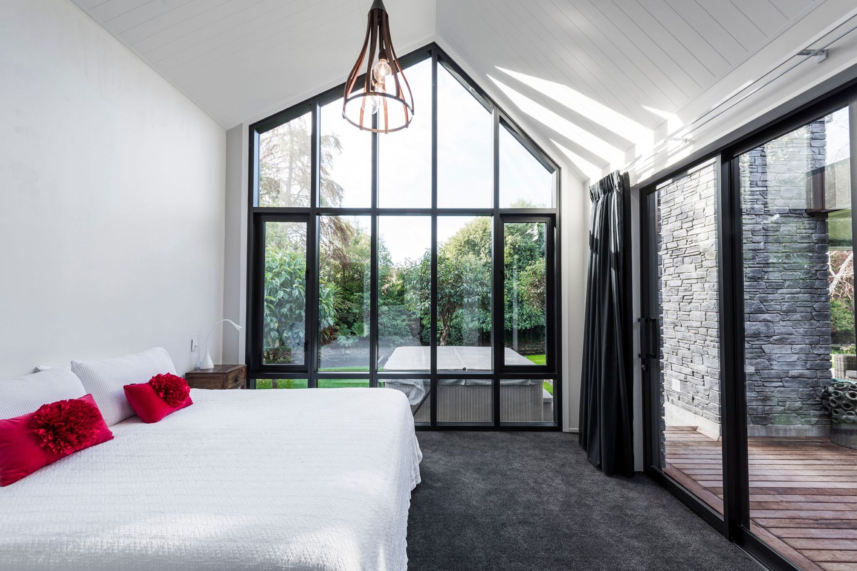 A bedroom with direct views out to the stream has the same asymmetrical apex repeated in its roofline.