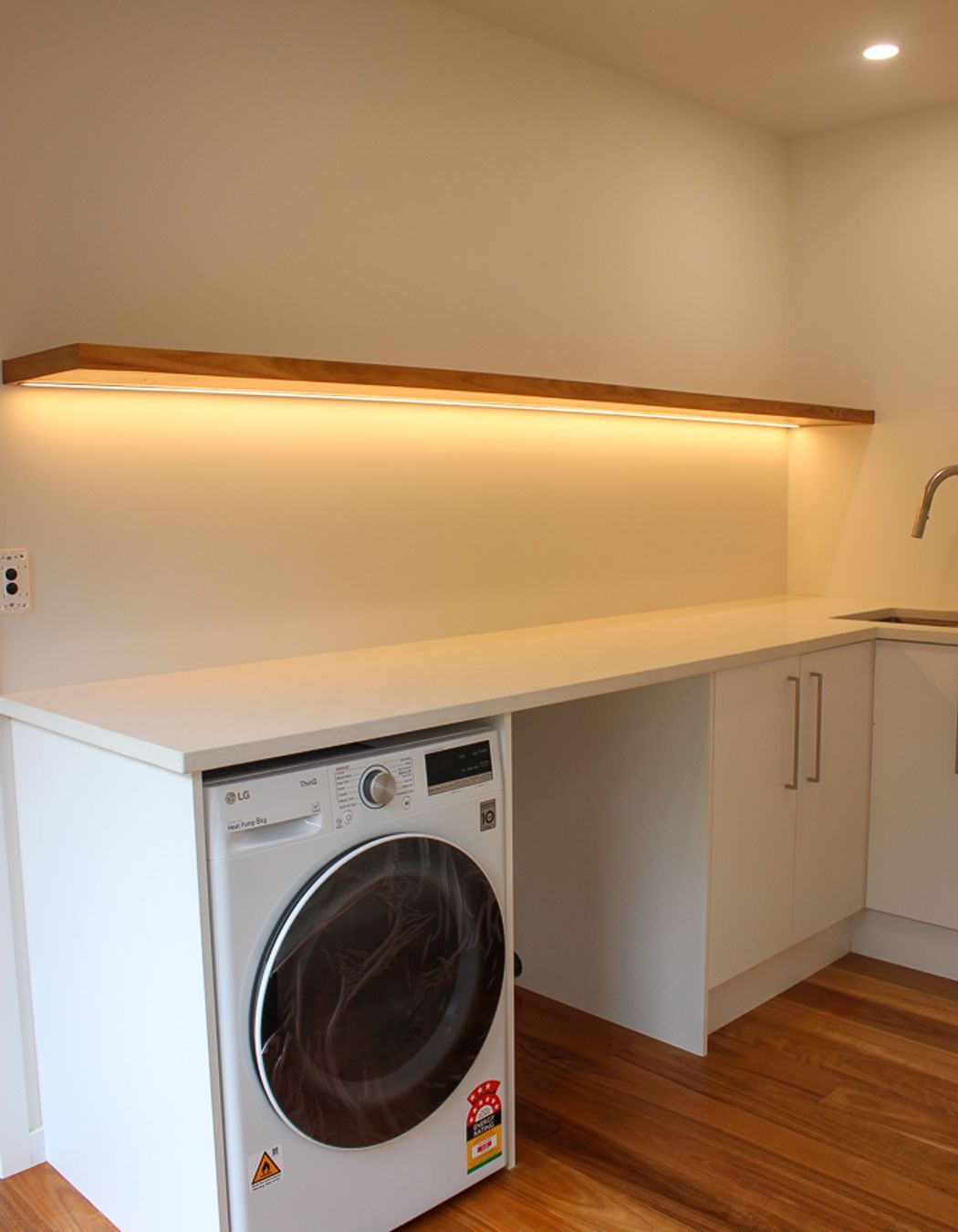 Blackbutt (Pilularis) timber overlay on the floors and the custom built floating shelf give this functional laundry a high-end & luxurious feel. Keeping on top of the all laundry for a growing and busy family needn't be a chore with a space like this