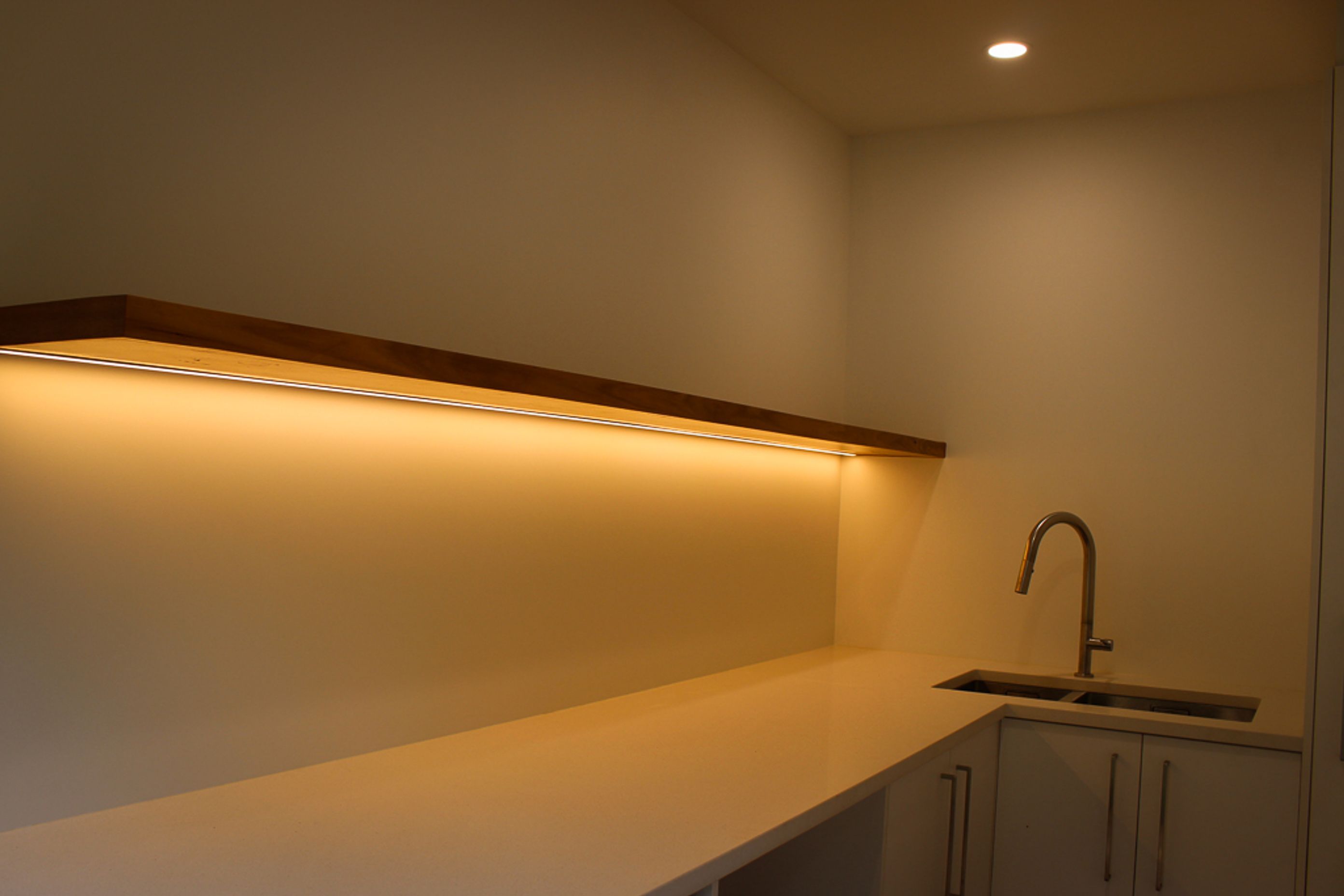 Blackbutt (Pilularis) timber custom built floating shelf give this functional laundry a high-end &amp; luxurious feel.  Inset strip LED lighting helps make this a really practical work area.