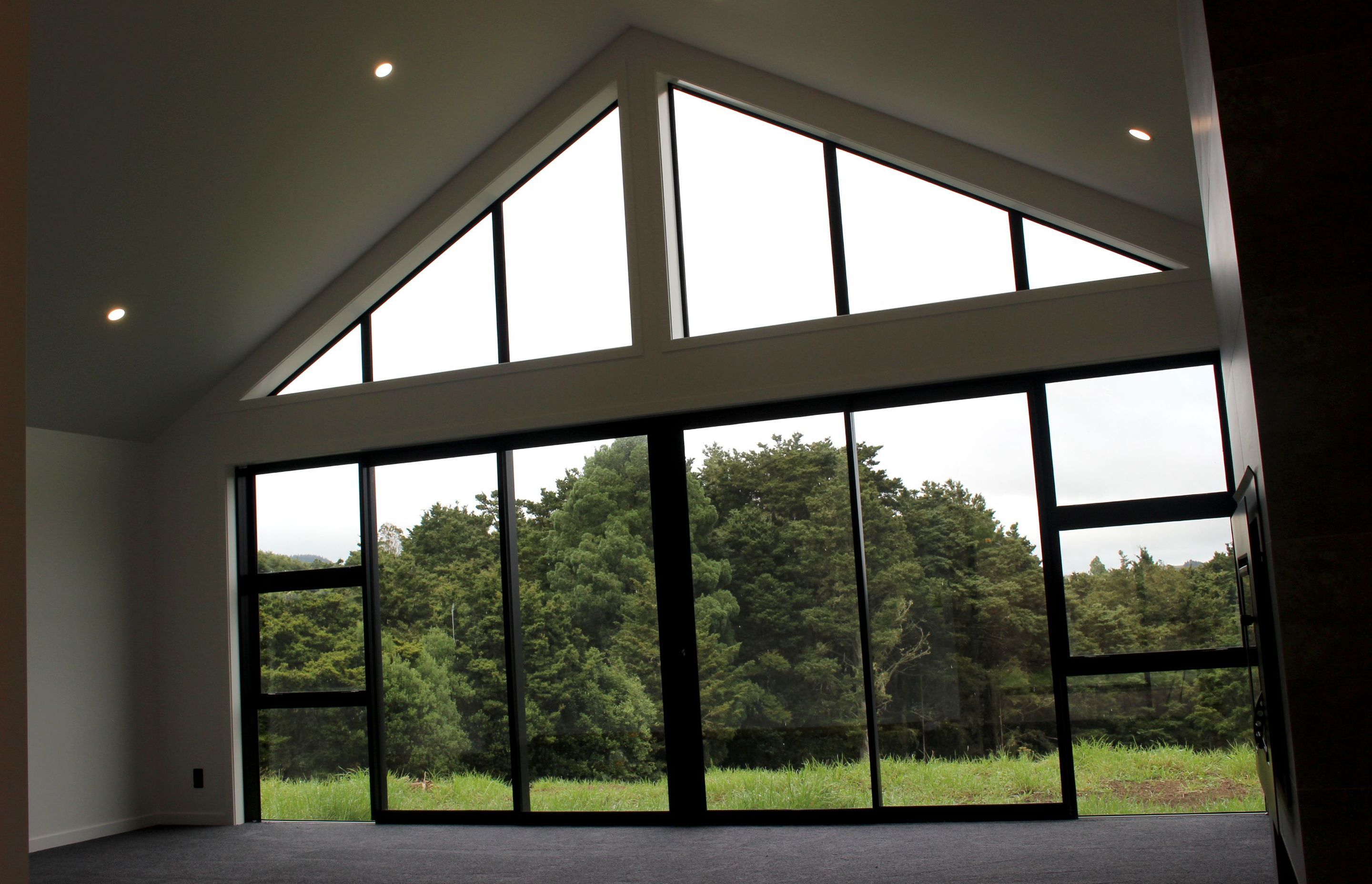 The main living space has glass sliders and glazing (from Elite Window &amp; Doors Whangarei) floor to ceiling to maximise the rural views and let the sun flood into the space.