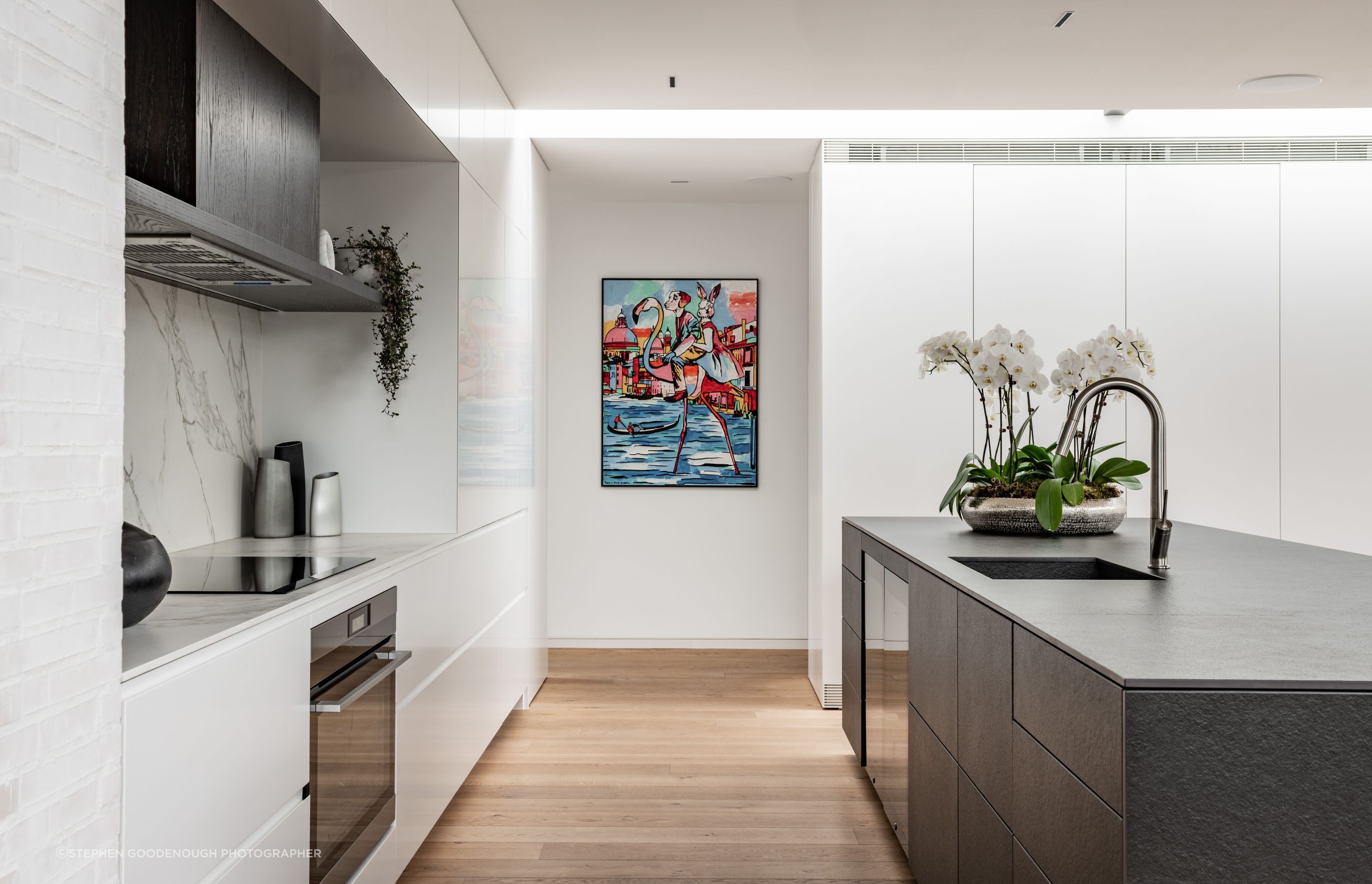 The doors to the scullery behind the joinery were especially hung so as not to expose their hinges when open, at the client’s request. The kitchen island is clad in Neolith stone. Tobin says appliances are integrated into the kitchen as much as possible. “It has two his-and-hers drink fridges built into it as well. It saves arguments.”