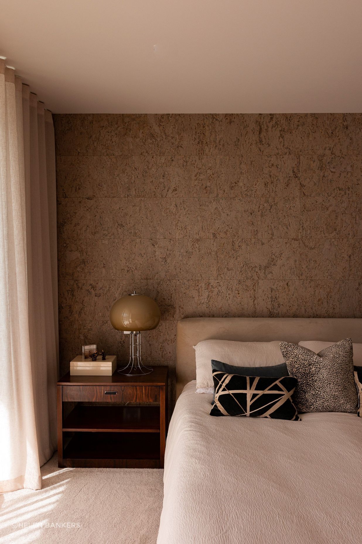 The cork feature wall brings warmth and texture to the bedroom.