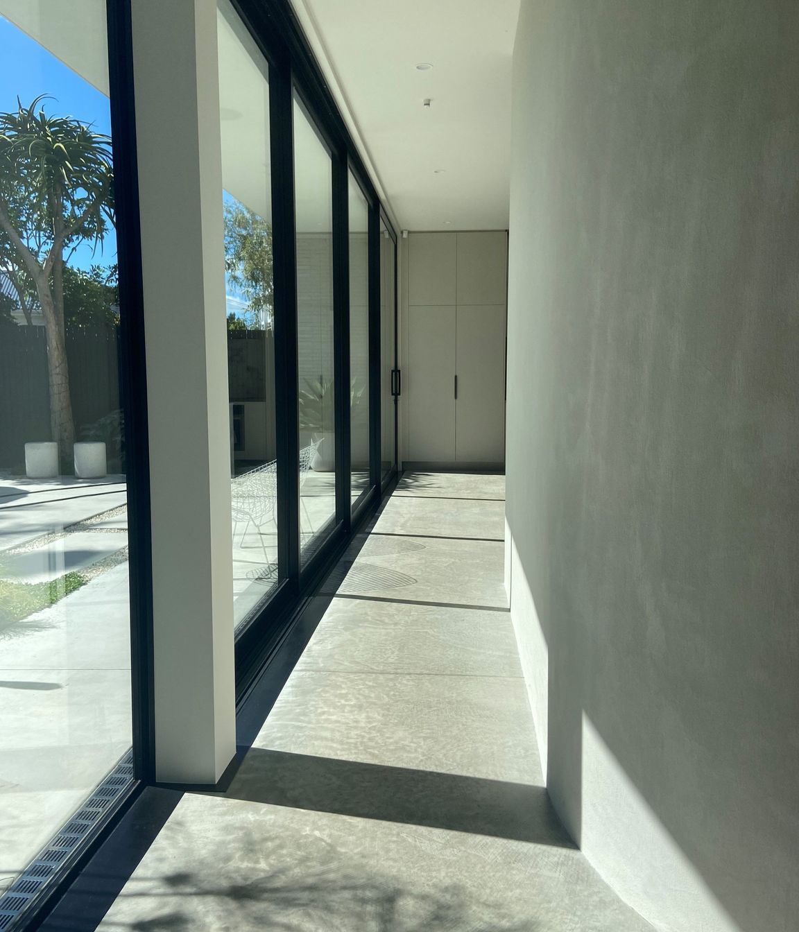 The gentle curve of the hallway wall guides you into the open-plan kitchen, dining, and living space.