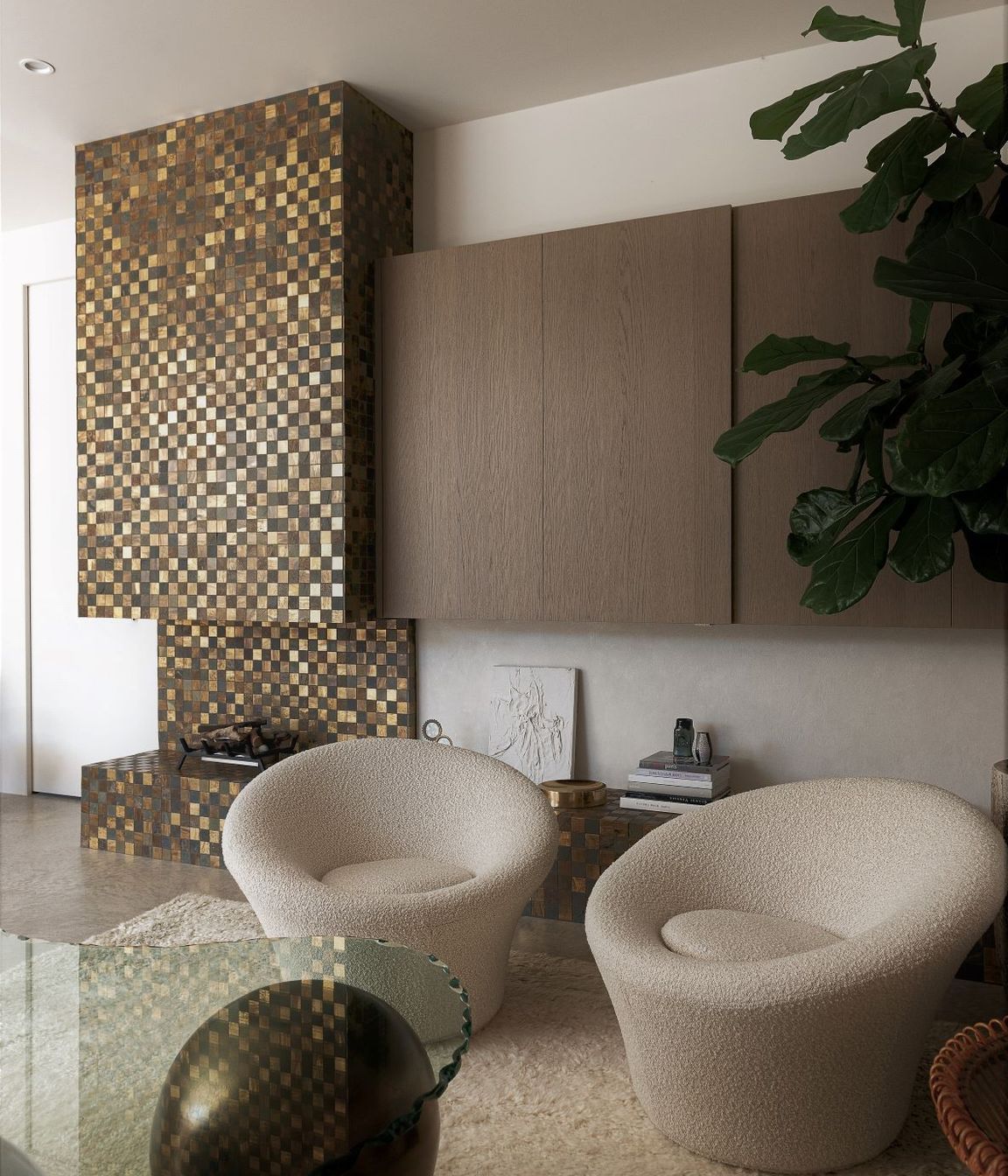 Tiny brass tiles were used to create this glittering façade for the fireplace, hearth, and chimney.