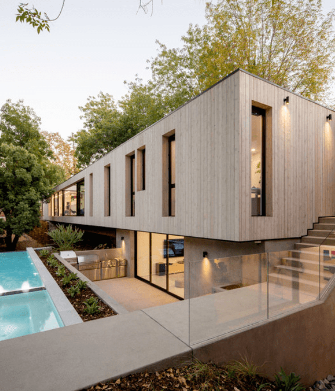 The exterior matches the minimalist aesthetic of the interior design - seen in the square-set timber façade and backyard pool area.