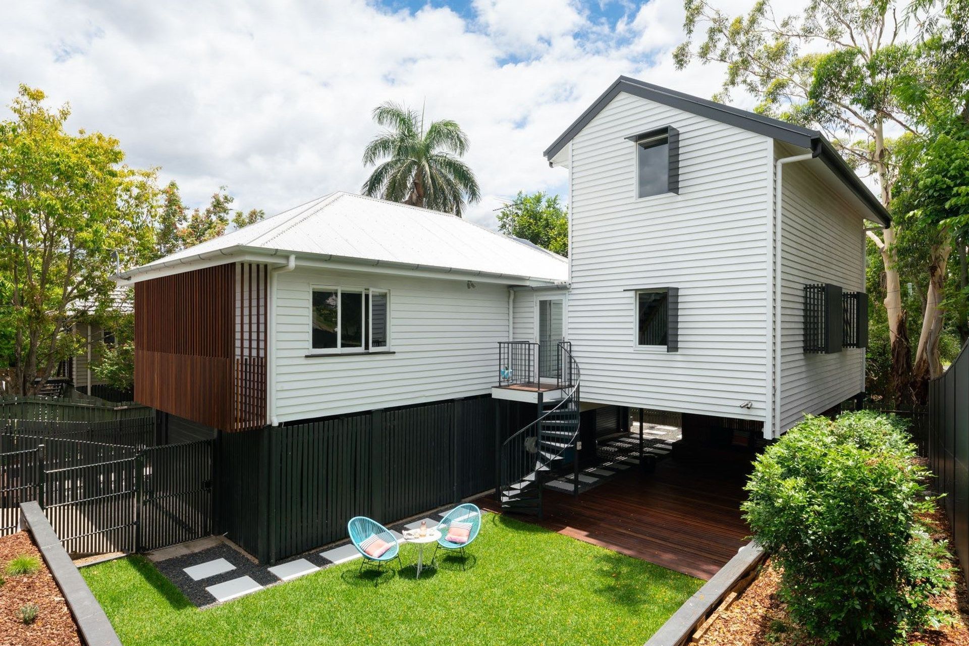 The extension is separated from the original house with a small link that connects access and conceals a completely private deck space behind. The spiral staircase brings a sense of whimsy to the journey to the outside world. The site is leveled and retained with improved stormwater absorption and dispersion incorporated.