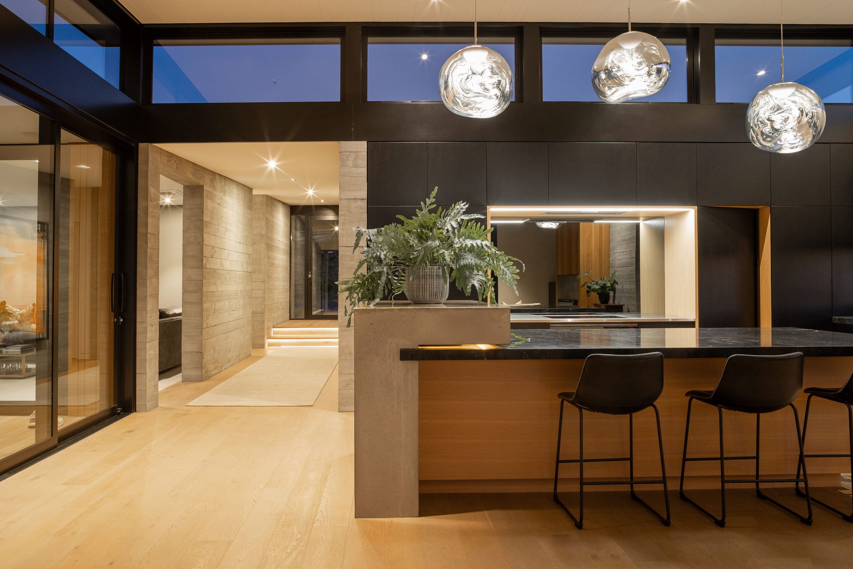 The solid concrete walls which run parallel through the home are broken by the large stacking sliders which flow out to the entertaining area.