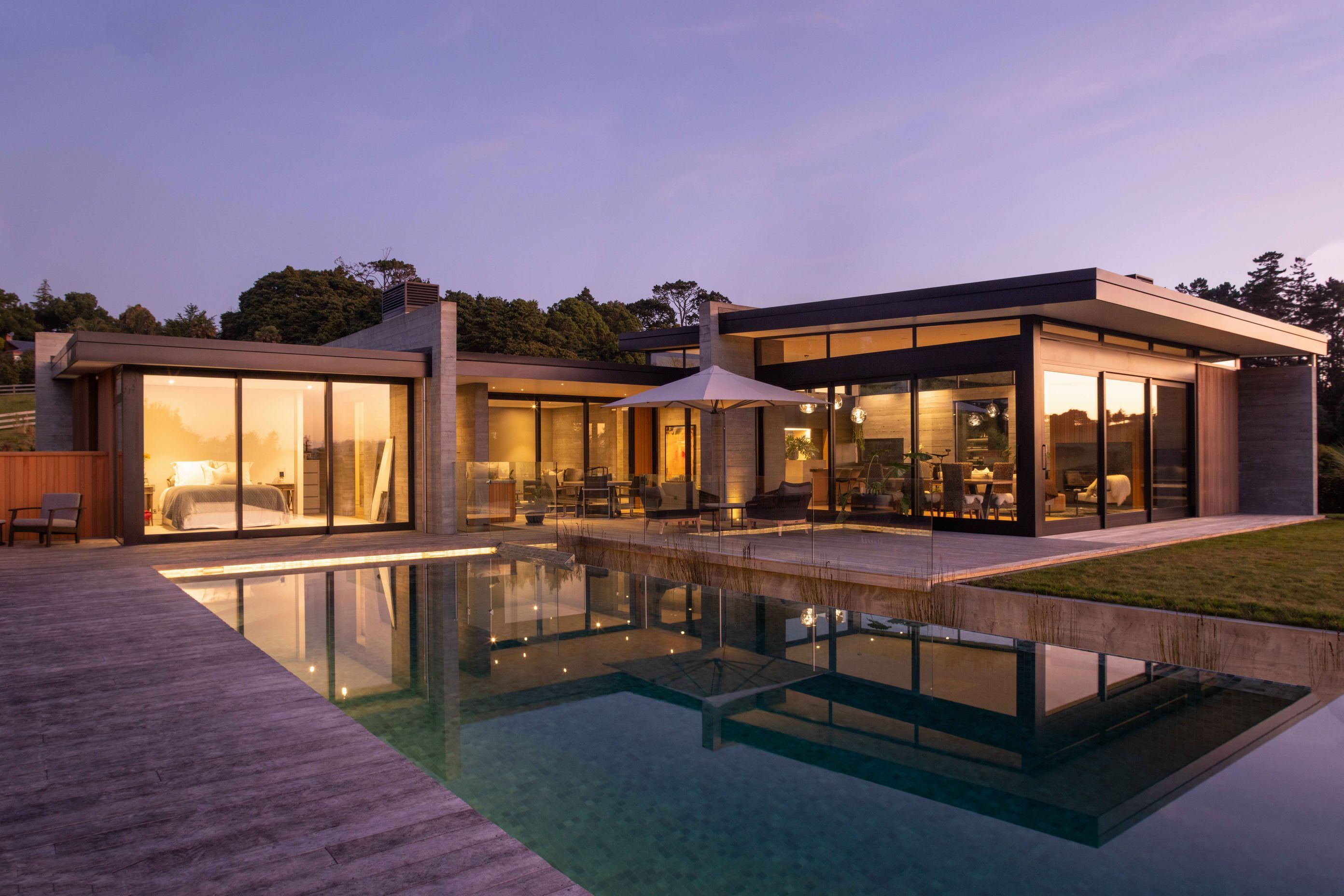 Large expanses of glass allow the glow from the interior to spill out over the exterior entertaining area and pool.