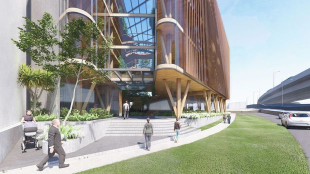 Architectural rendering of a contemporary multi-storey commercial building with a highly glazed entrance atrium, curved projecting balconies, extensive vertical timber-look screening, exposed angled structural supports, and landscaped pedestrian terraces. A highway or elevated roadway is visible alongside the building.