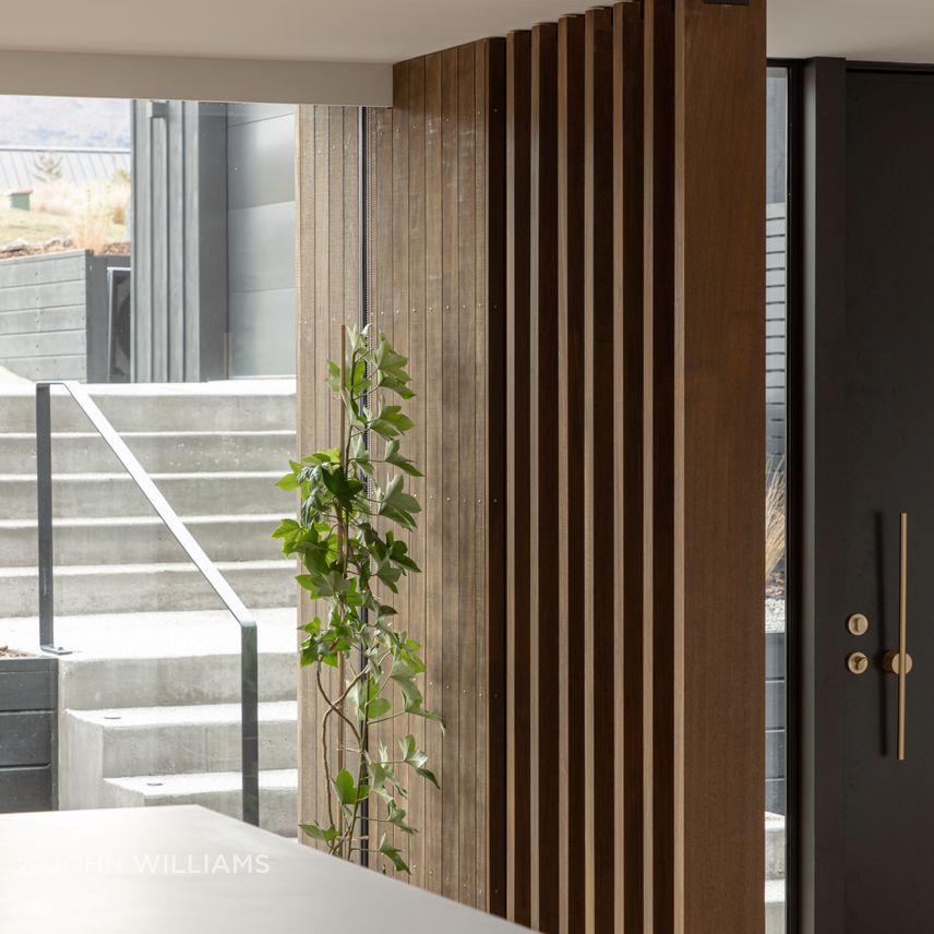 External concrete aggregate steps lead to the main entrance of the home