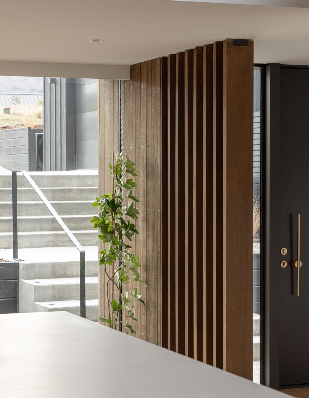 External concrete aggregate steps lead to the main entrance of the home