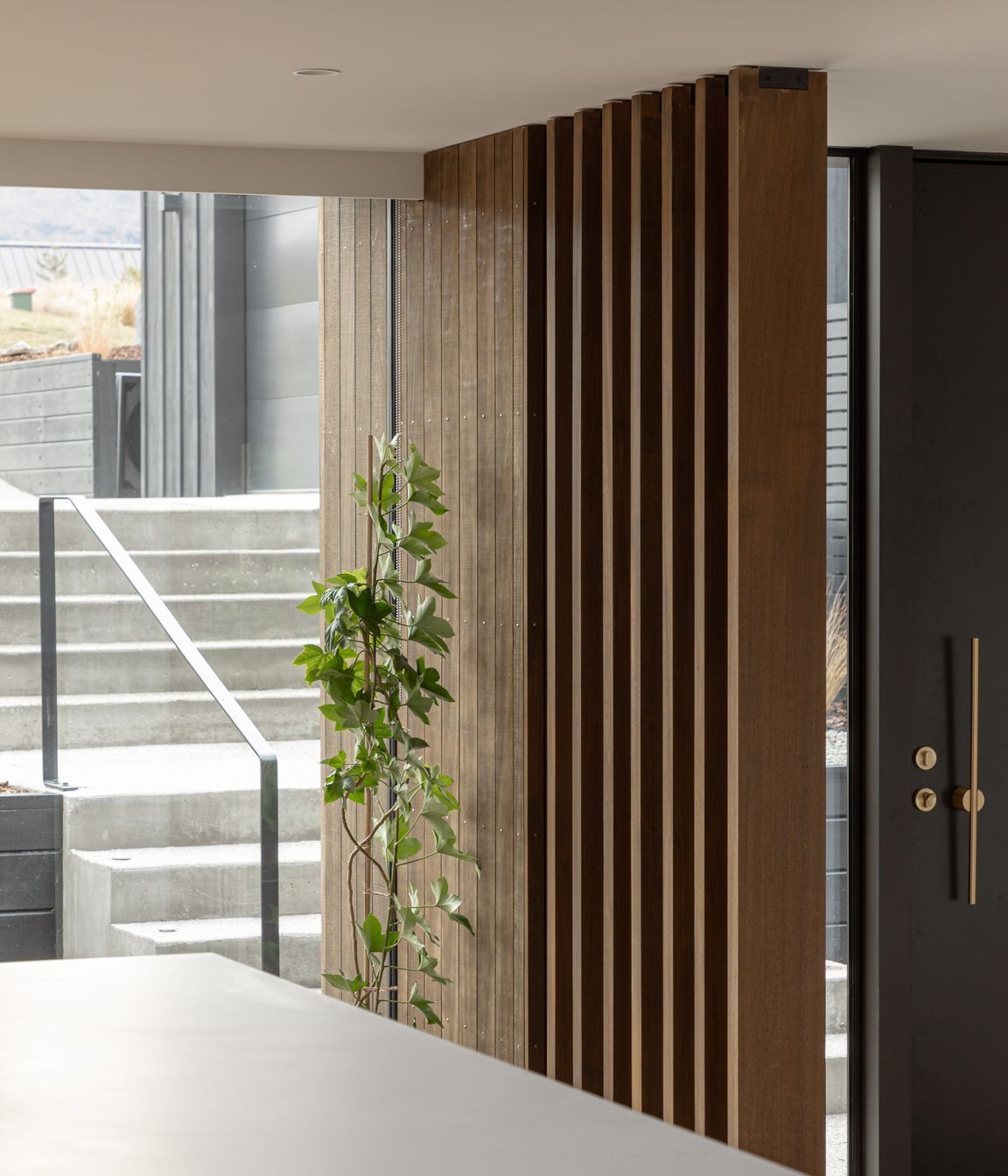 External concrete aggregate steps lead to the main entrance of the home