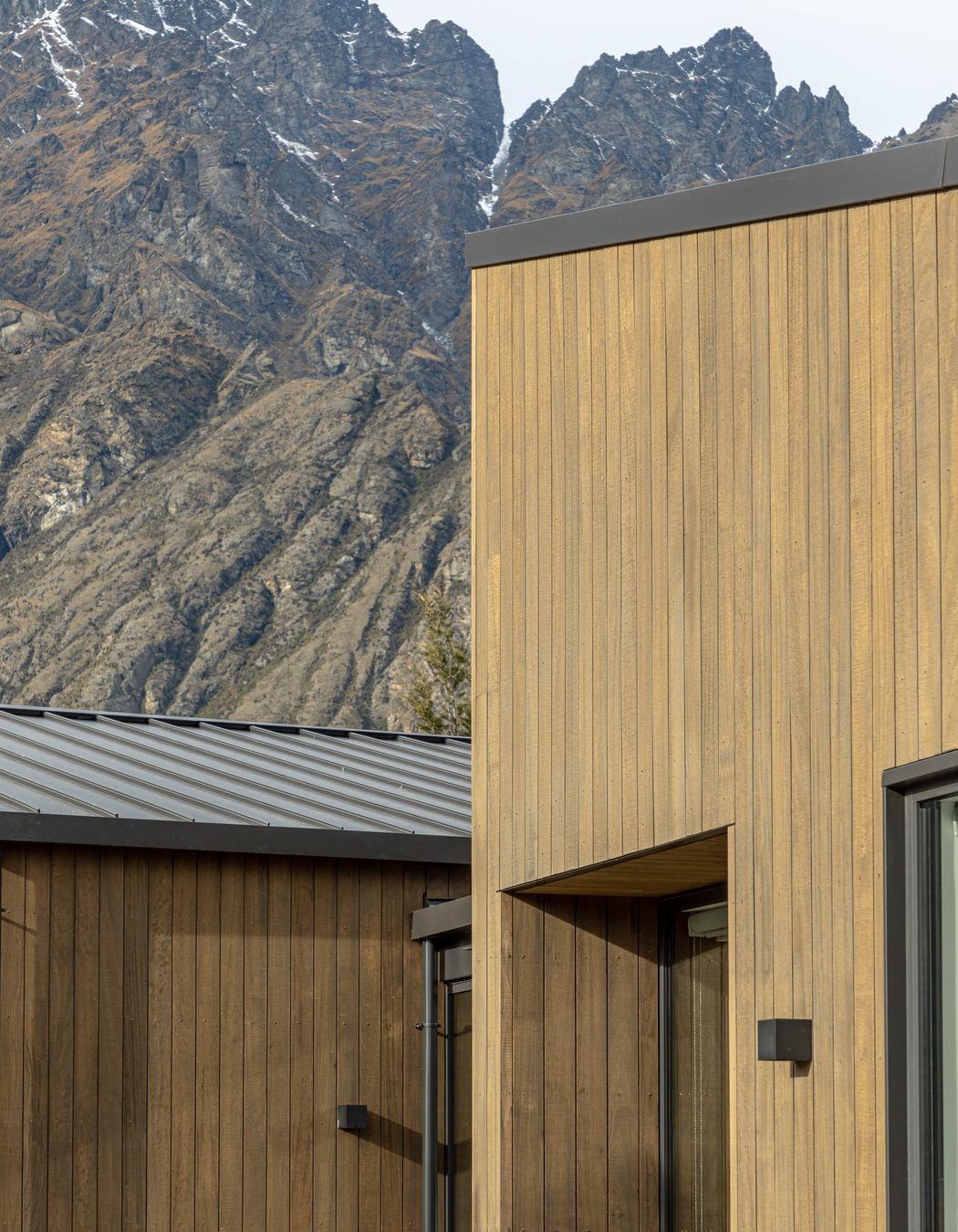 The earthy tones of this home sit comfortably against the rugged mountain backdrop