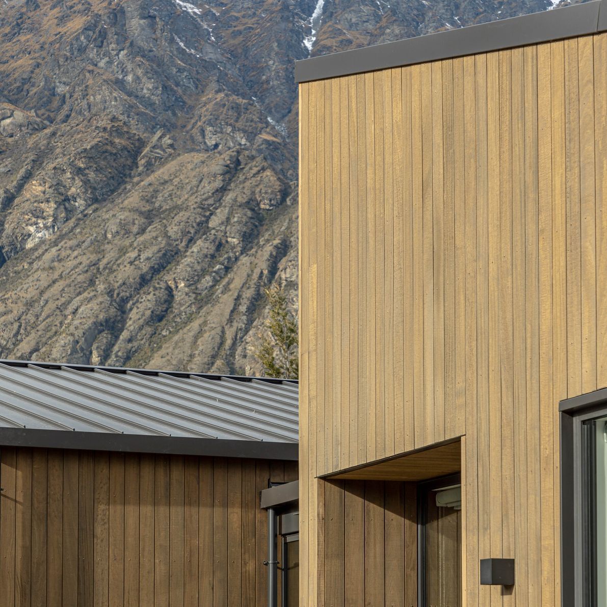 The earthy tones of this home sit comfortably against the rugged mountain backdrop